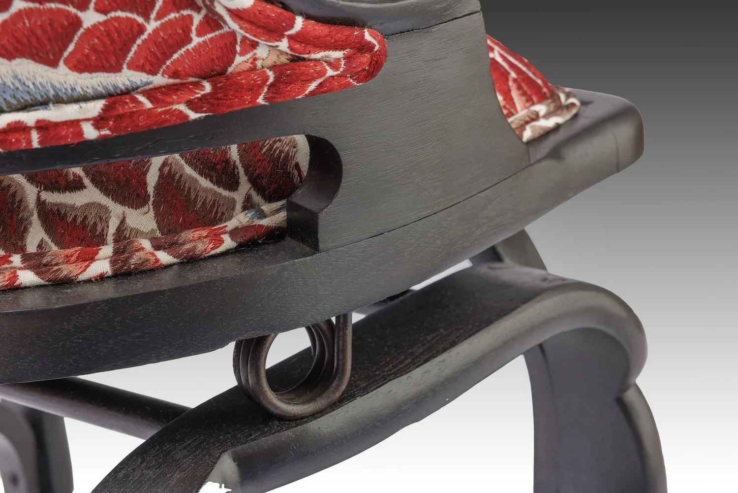 Close detail of the concealed coil spring beneath the seat that allows the recline.