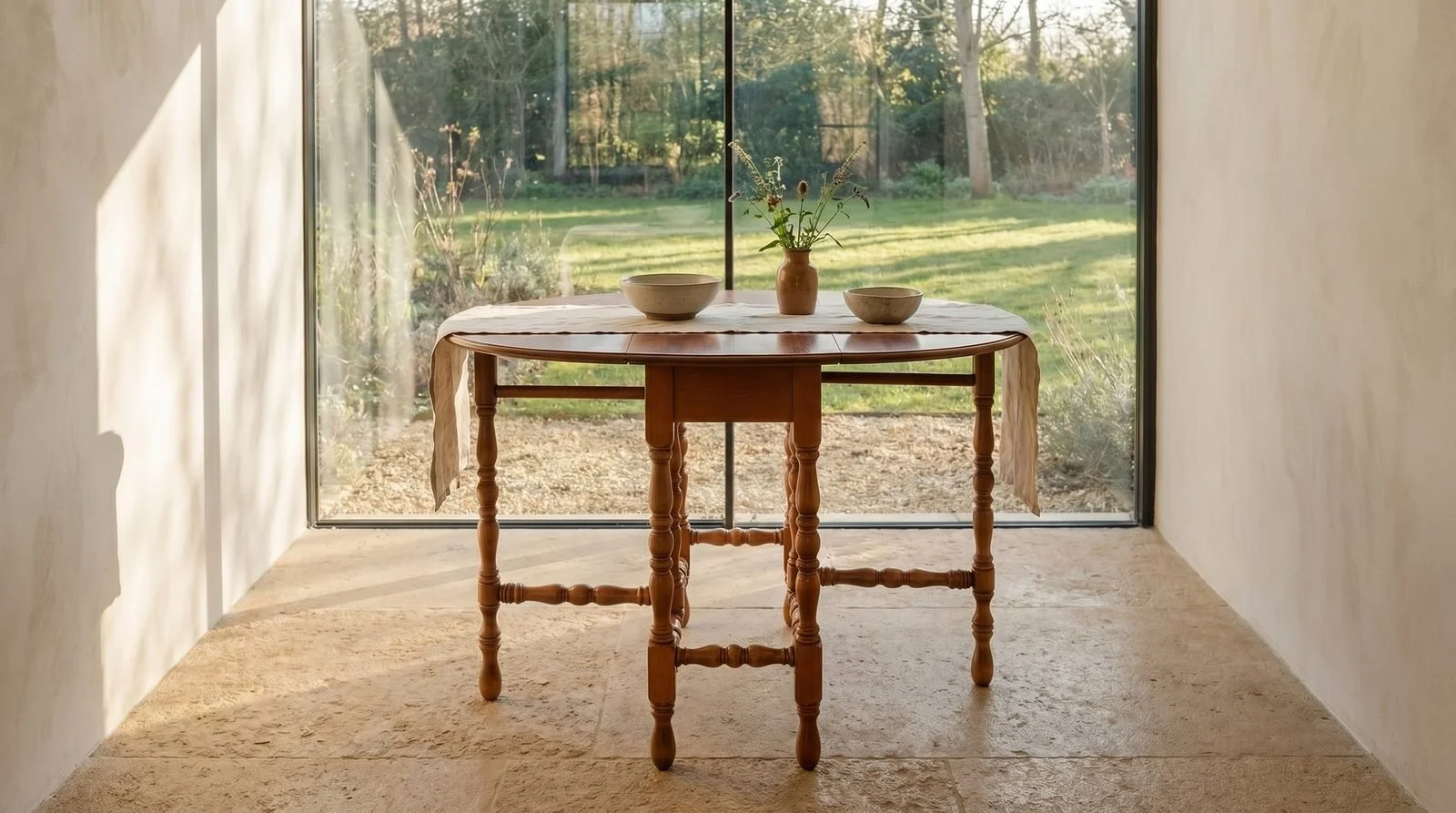 Gateleg table open in a room, on a wood floor