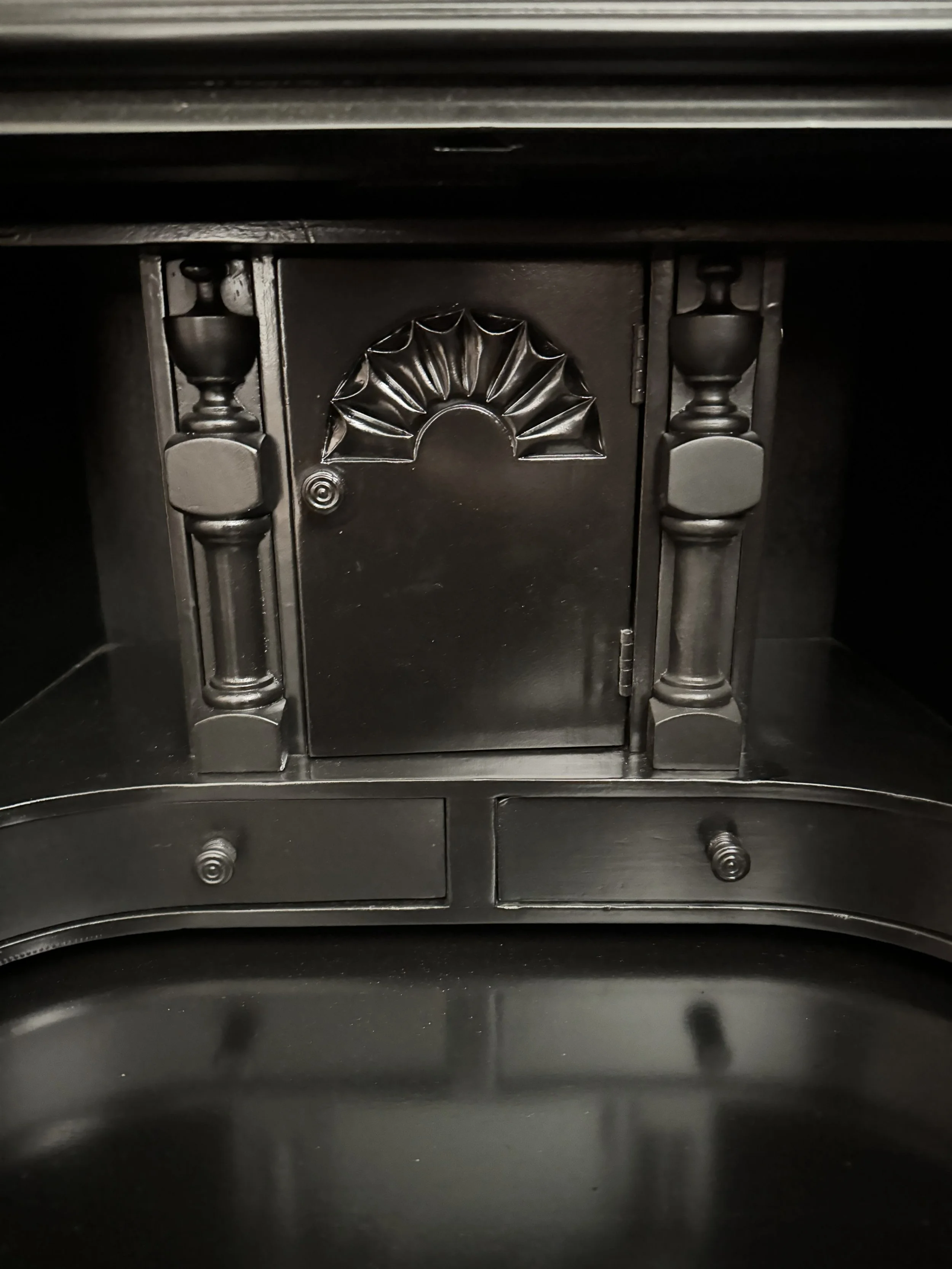 Fitted interior center: a prospect door carved with a fan shell, flanked by turned column document dividers, above two small drawers