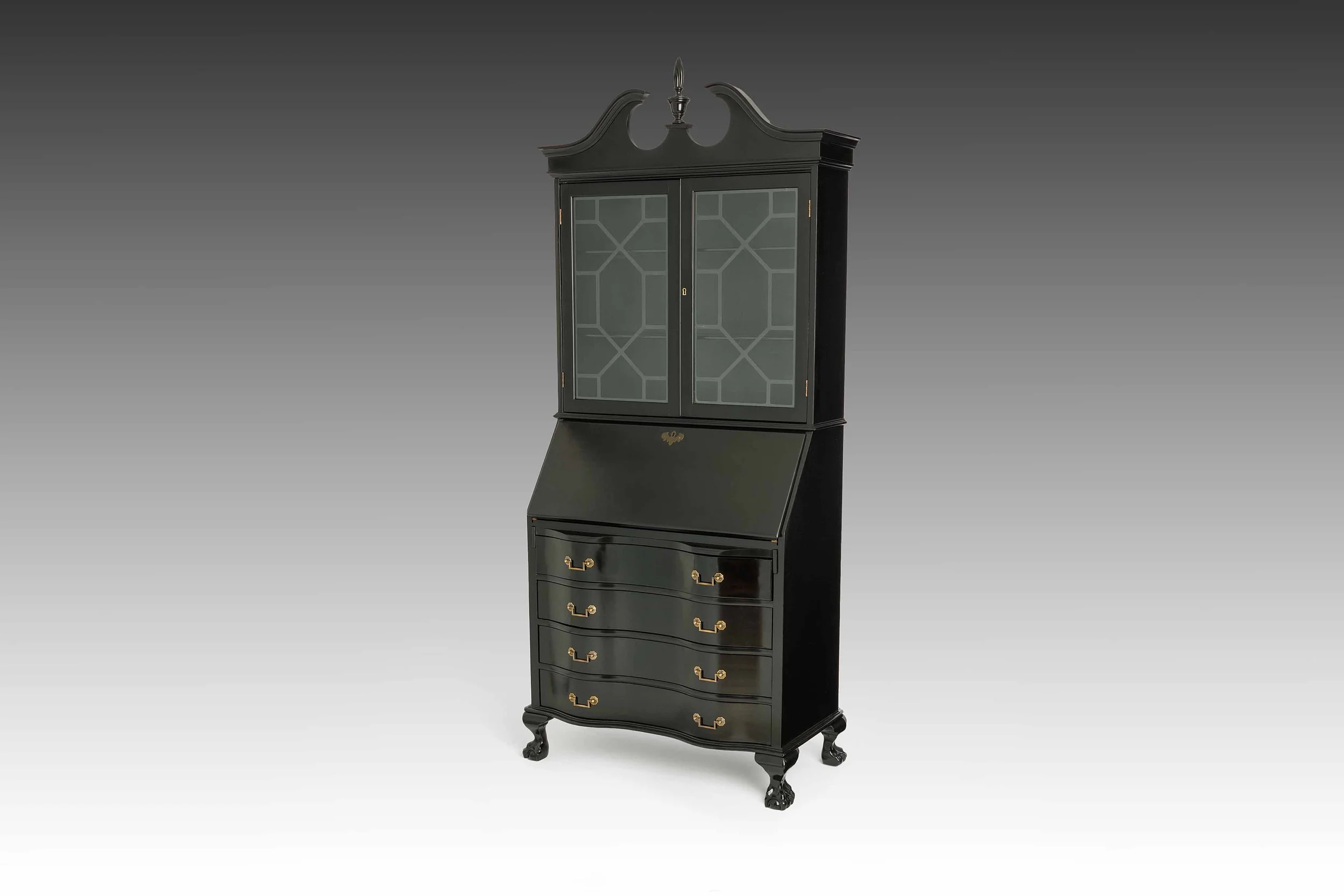 Front view of The Obsidian Atelier secretary desk with the writing compartment closed, showcasing its satin black finish, brass hardware, and glazed upper hutch.