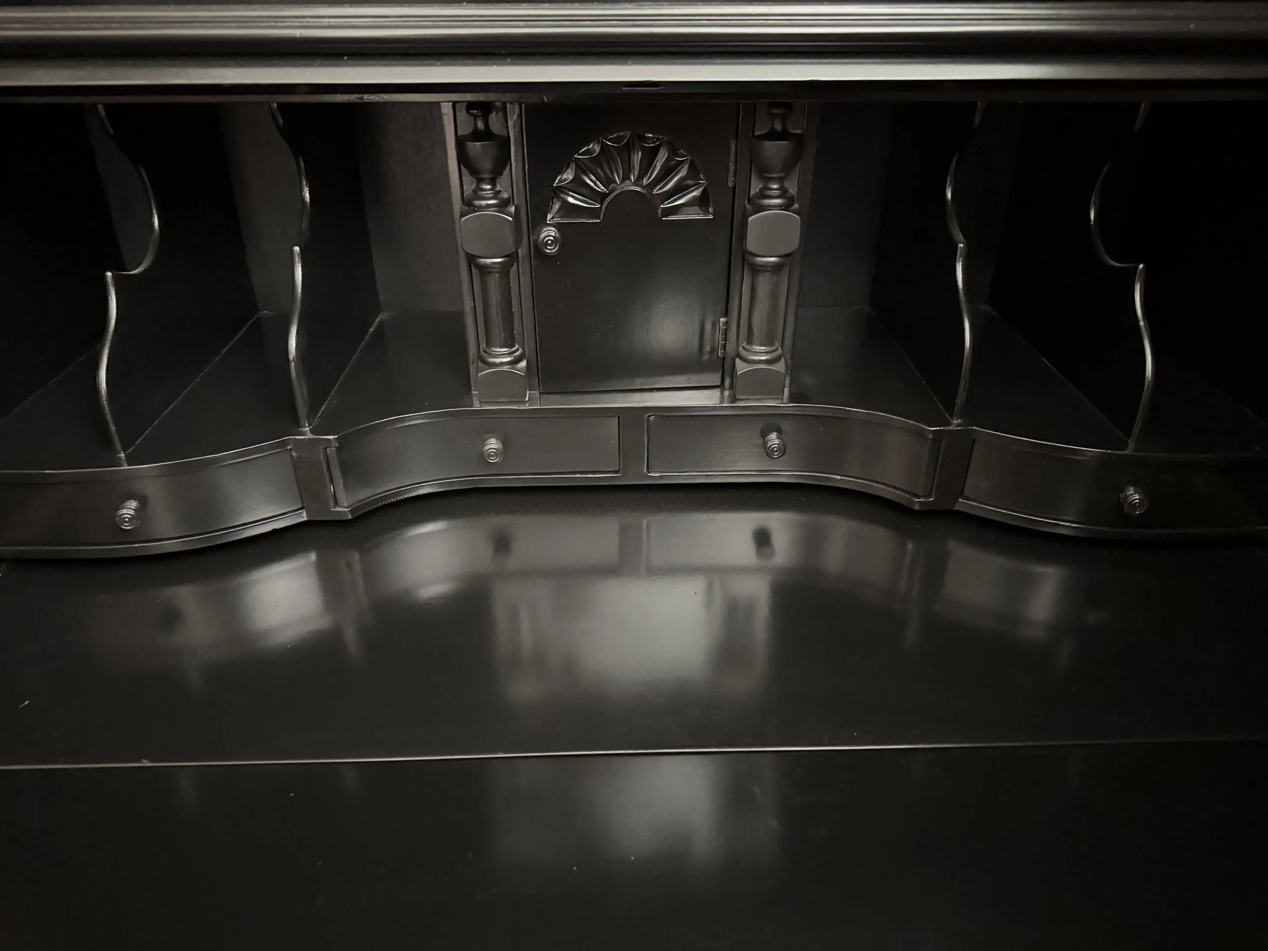 Fitted secretary interior with shaped pigeonhole dividers, a central carved prospect door, and a row of small drawers over the fall-front writing surface