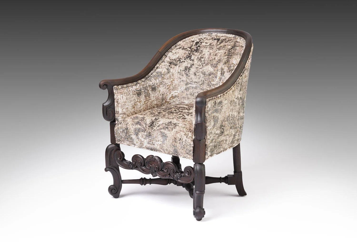 Early twentieth-century parlor tub chair, its semicircular back curving without a break into low arms, upholstered in rose, mauve and charcoal velvet over a gold-toned ground, on splayed dark-stained legs