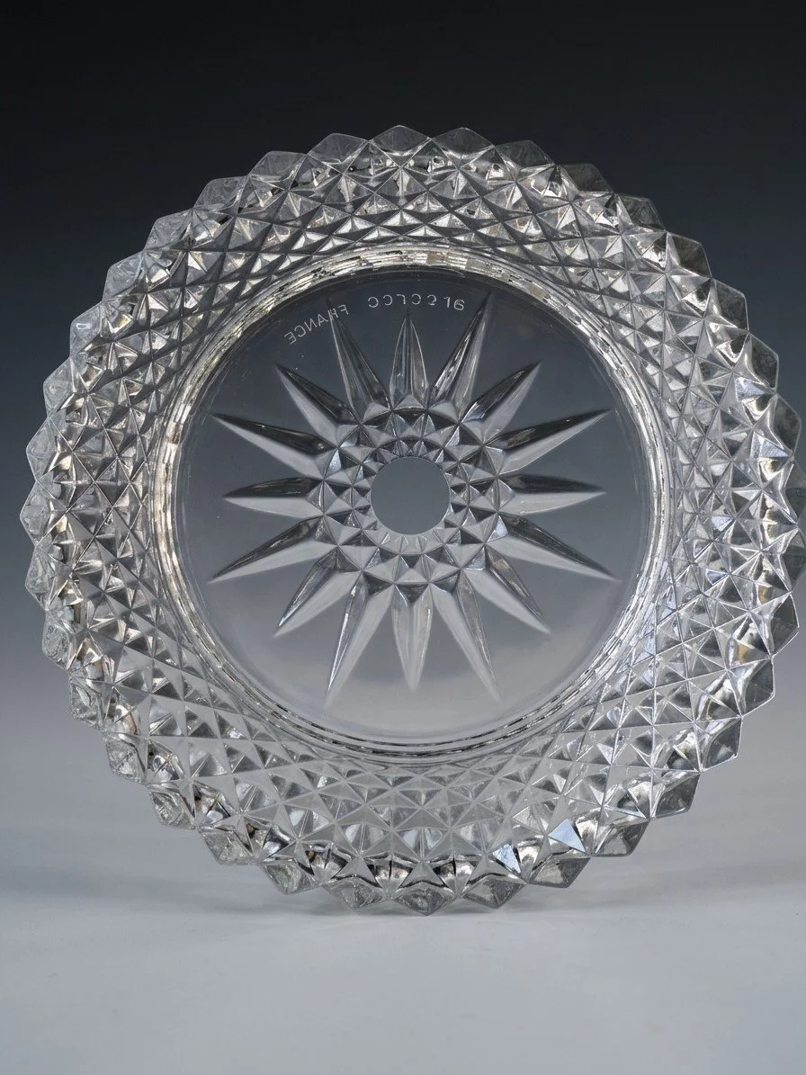 The underside of the bowl, a molded star at the center ringed by a smooth band carrying the words arcoroc France, with the diamond-point pattern running out to the rim