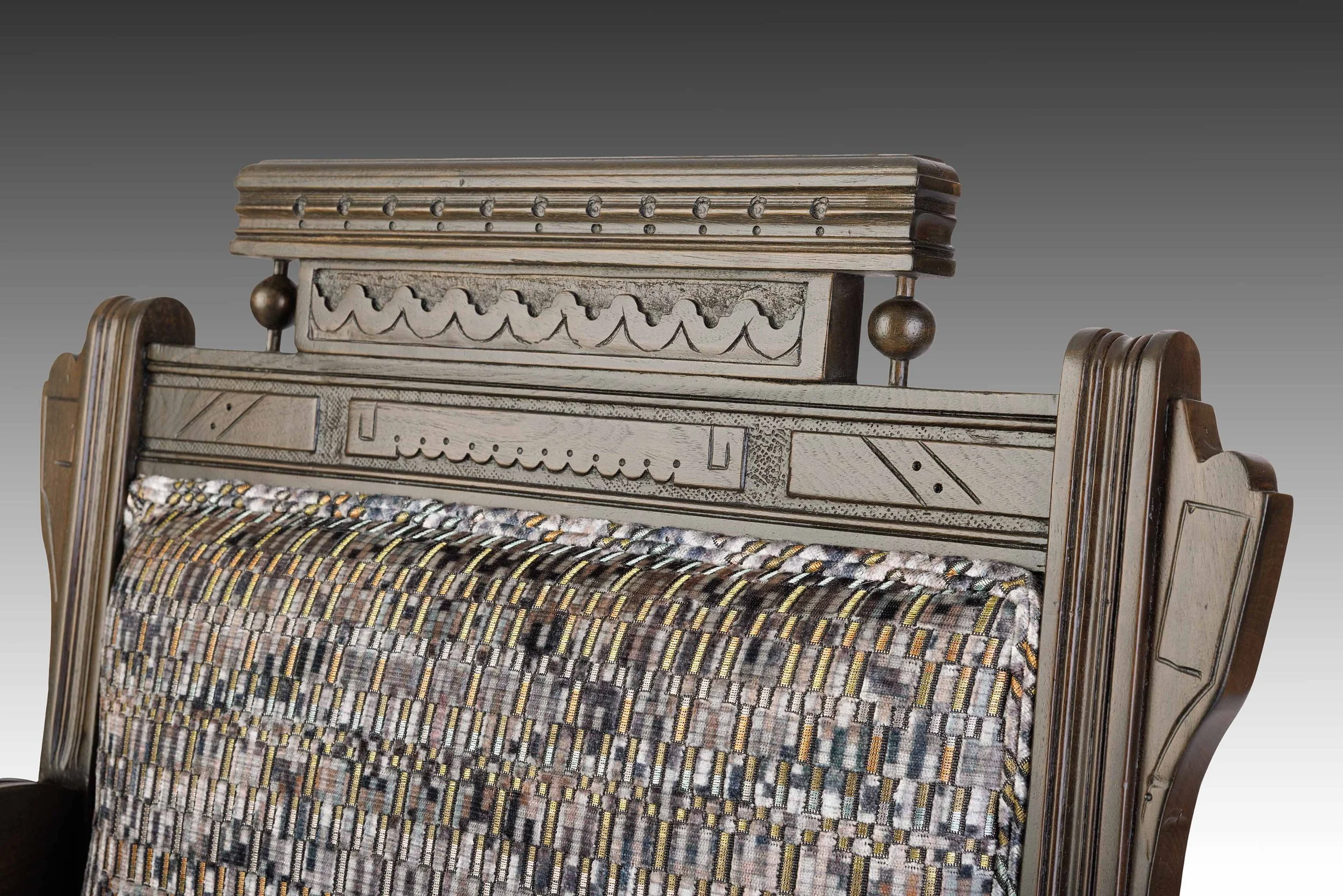 Architectural wood crest featuring chip-carved motifs, spheres, and stacked molding.