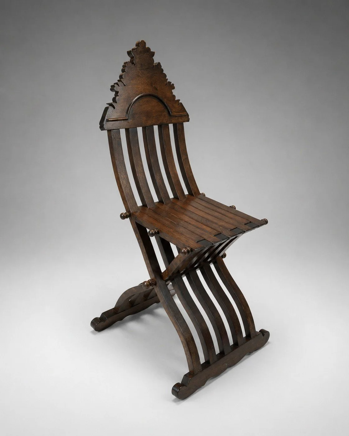 Savonarola Linea folding chair in dark stained wood shown in three-quarter view with curved slat back and X-frame base
