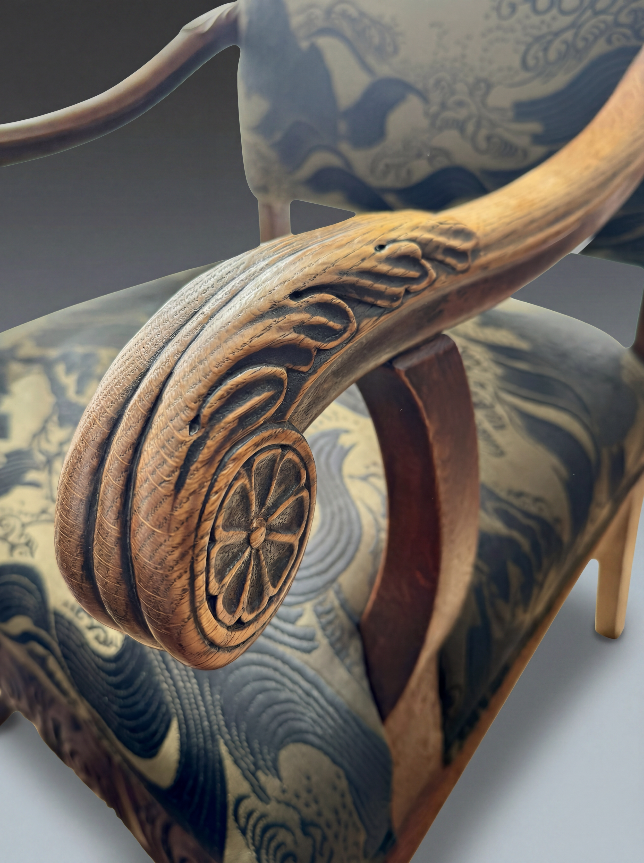 Close detail of carved oak arm with visible wear, tonal variation, and surface change from repeated contact.