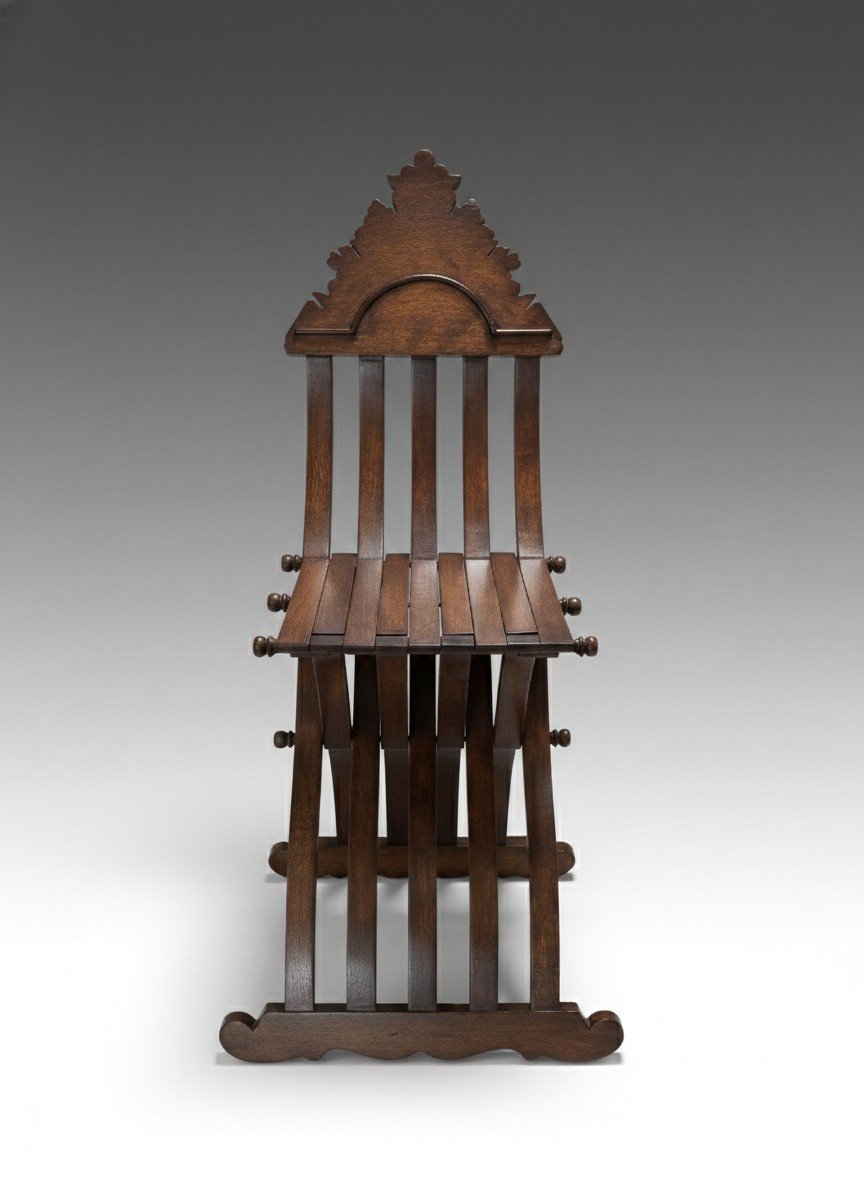 Savonarola Linea folding chair in dark stained wood shown in front view with curved slat back and X-frame base