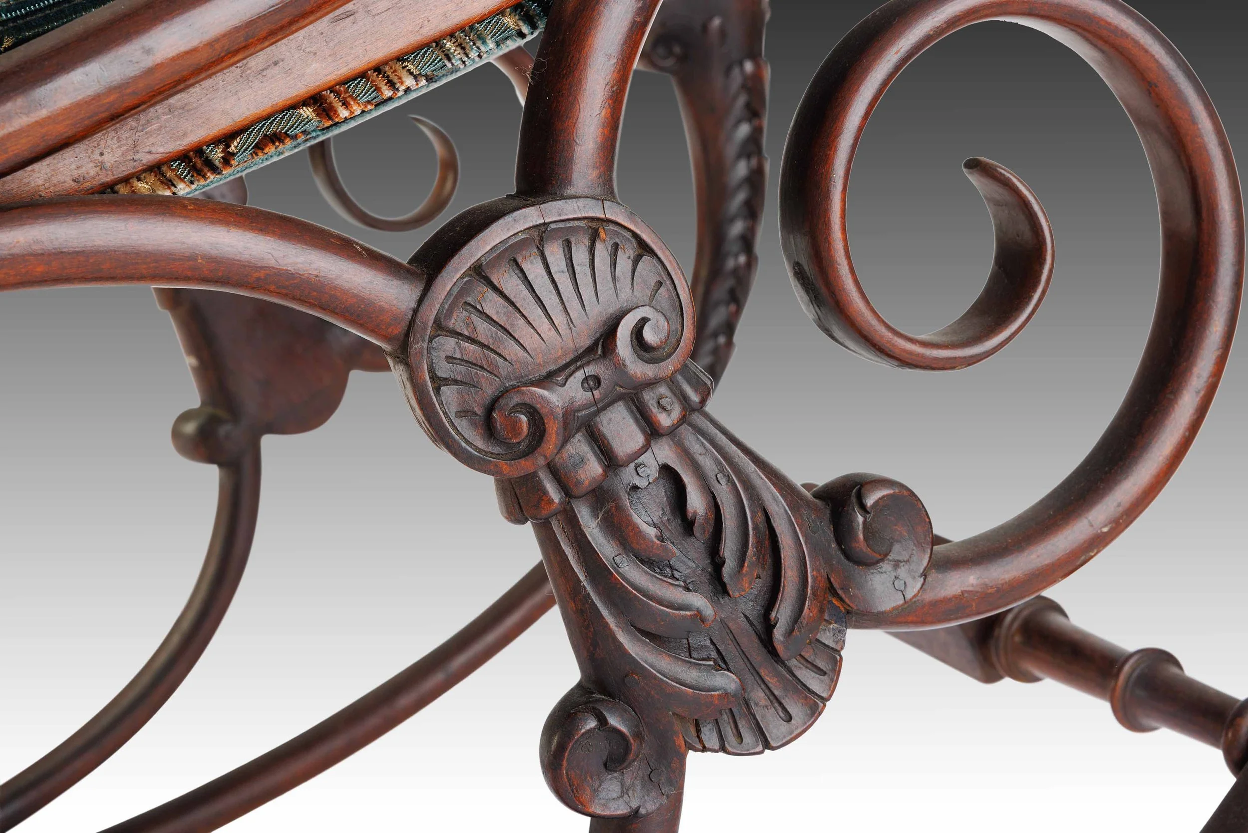 Detail of lower scroll motif and carved support structure on The Lioncourt Rocker’s base, emphasizing Victorian craftsmanship.