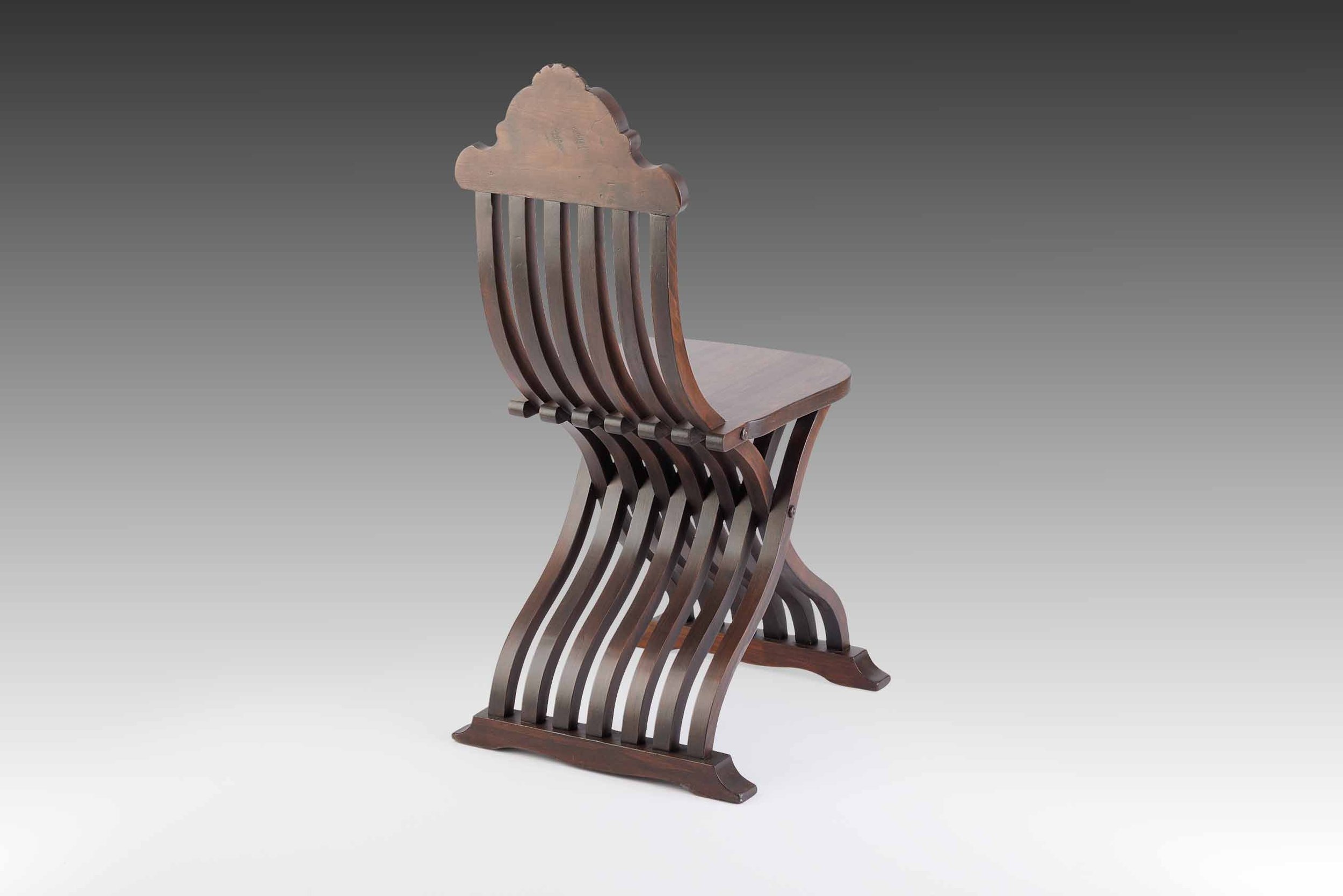 Single Italian Renaissance Revival chair in sedia tenaglia form with curved slatted back and sculptural base.