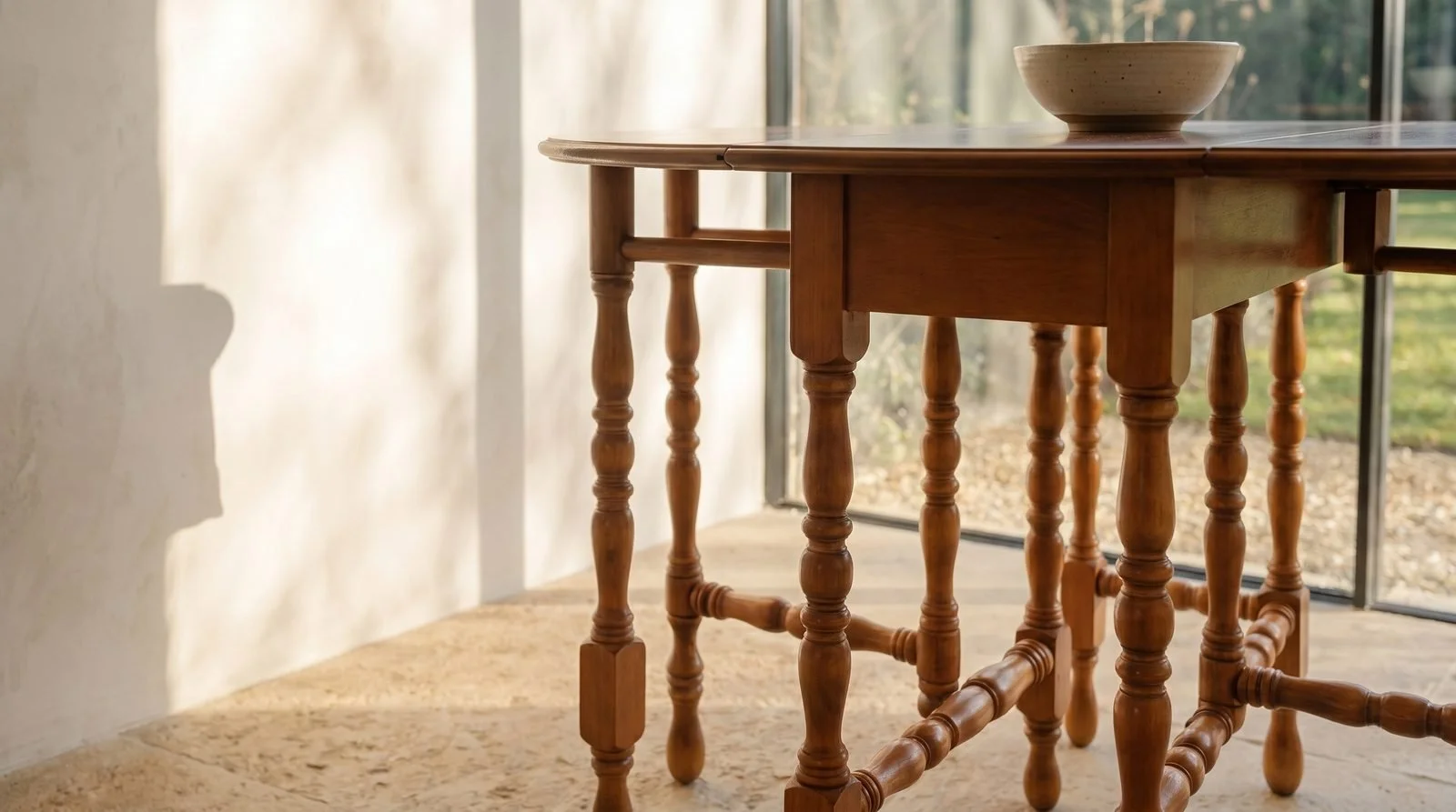 Detail of Gateleg table open in a room, on a wood floor