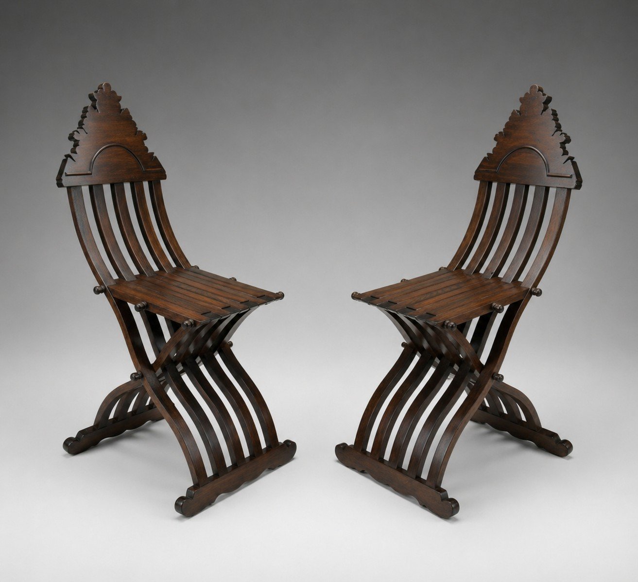 Pair of Savonarola Linea folding chairs facing inward showing symmetrical form and sculptural curved bases