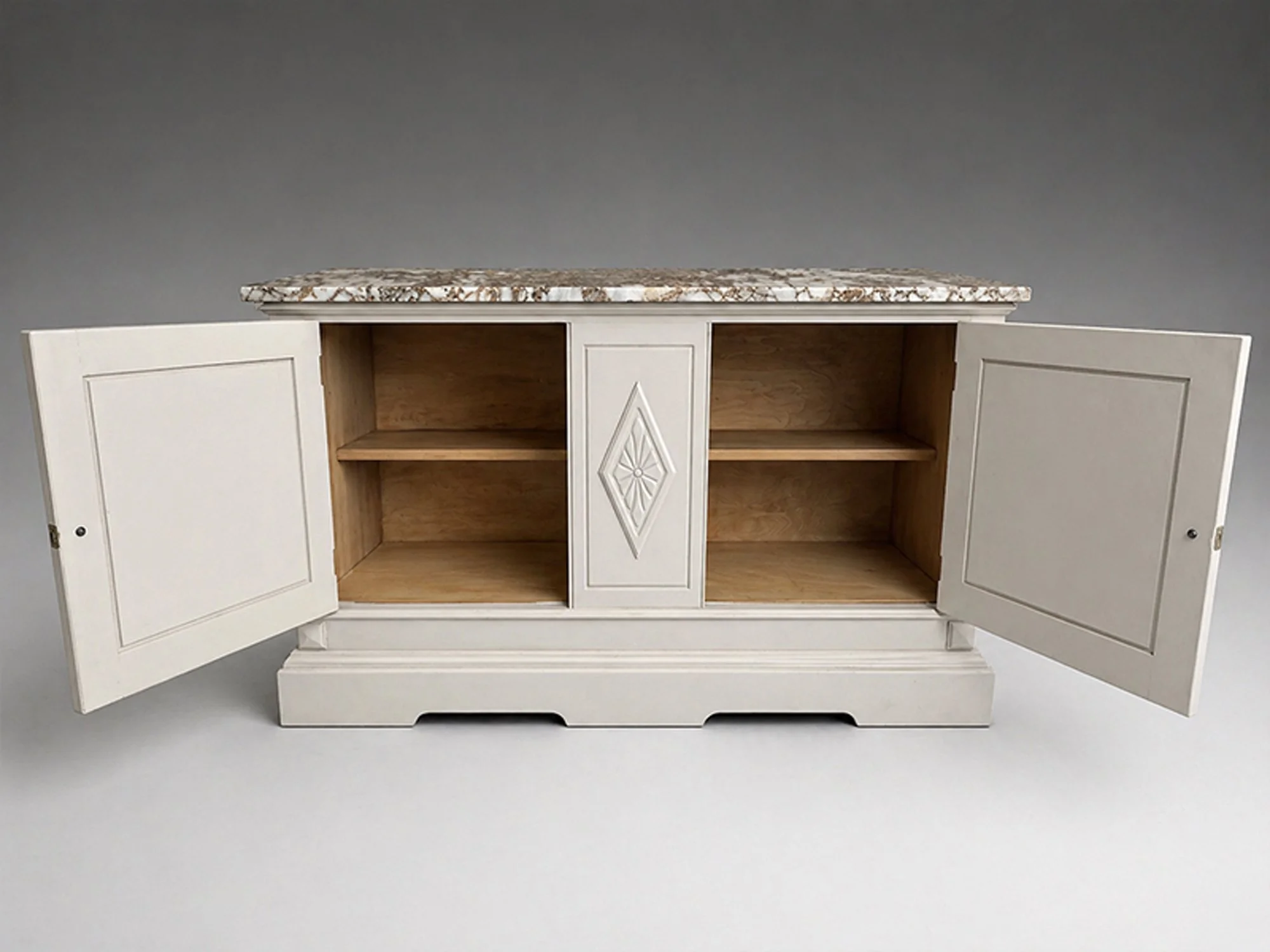Painted antique cabinet with doors open, revealing interior shelving and natural wood interior beneath a fitted stone top