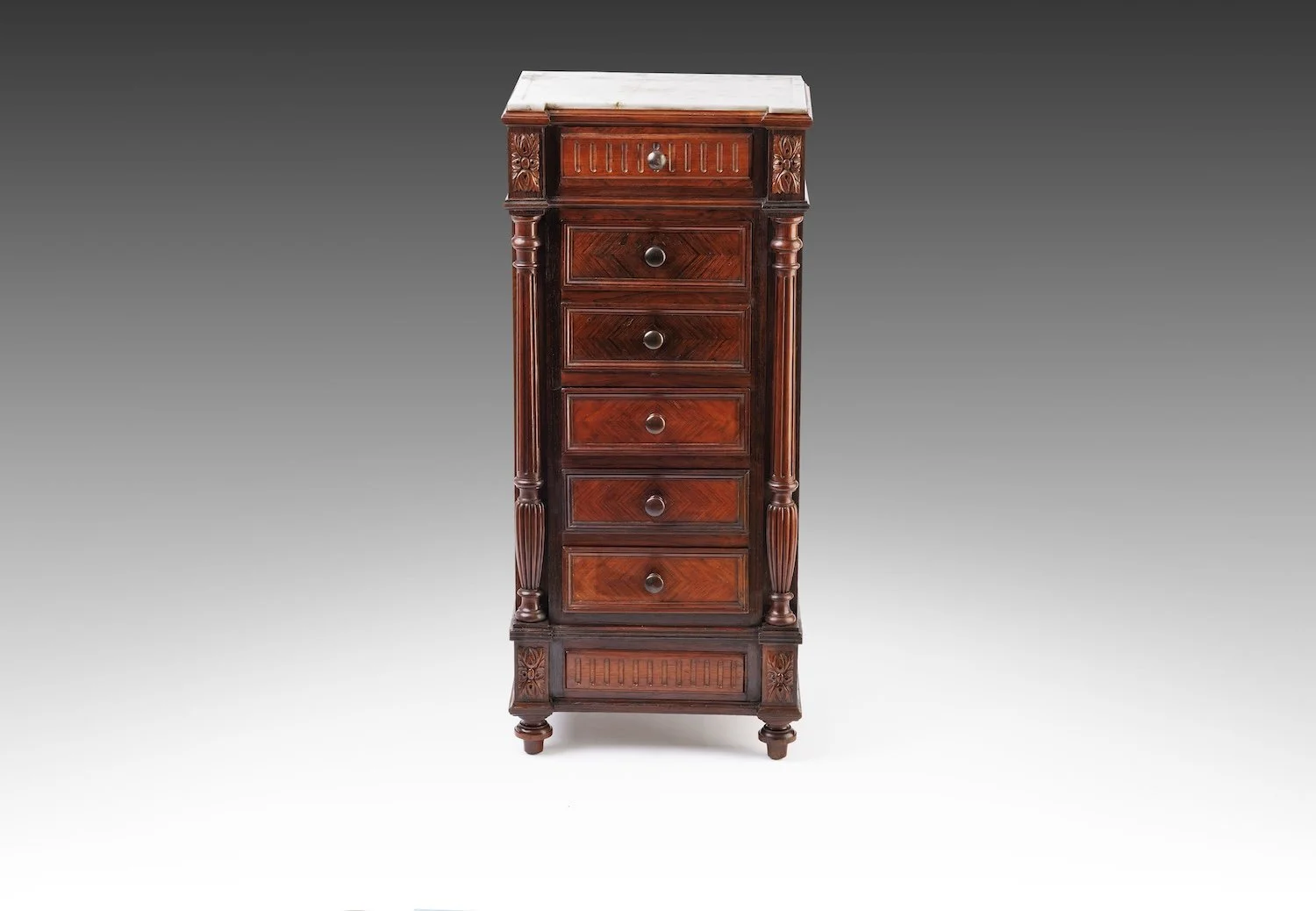 Front view of the Renaissance Revival bedside cabinet with fluted half-columns, carved corner blocks, and graduated drawers below the marble top.