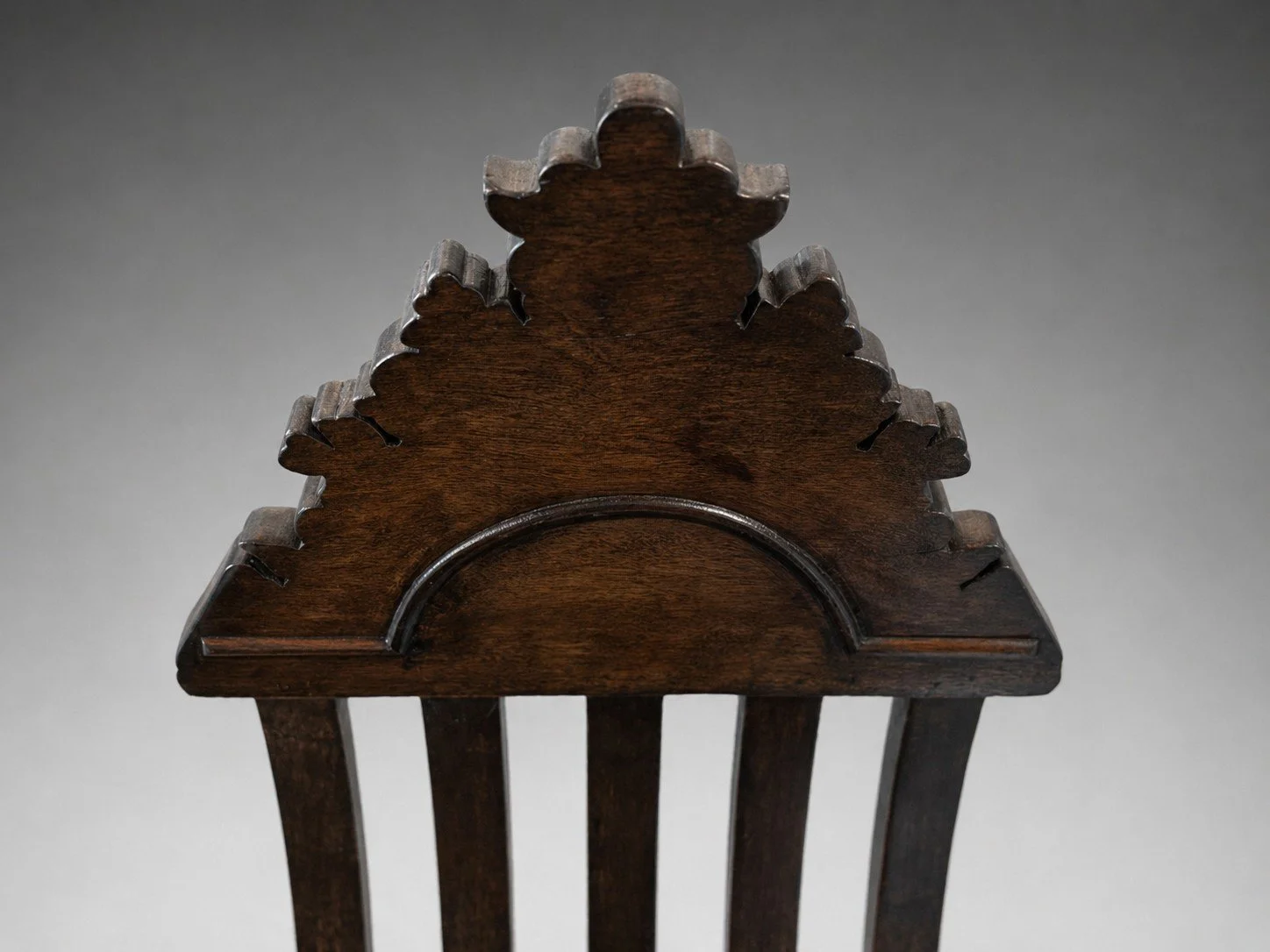 Close-up of Savonarola Linea chair crest showing carved top rail and arched detail in dark wood finish