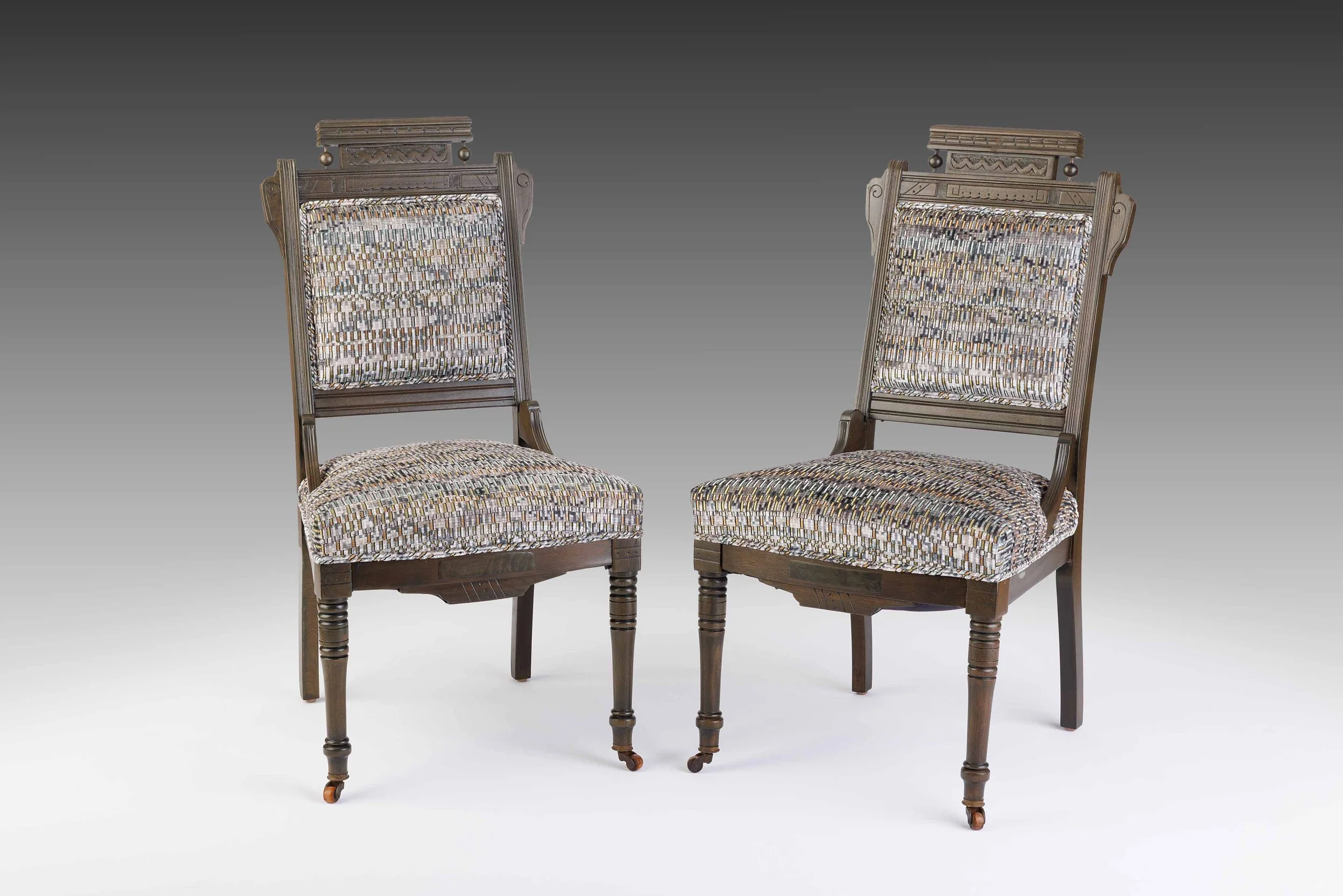 Pair of Eastlake-inspired side chairs in printed velvet with carved backs and turned legs.