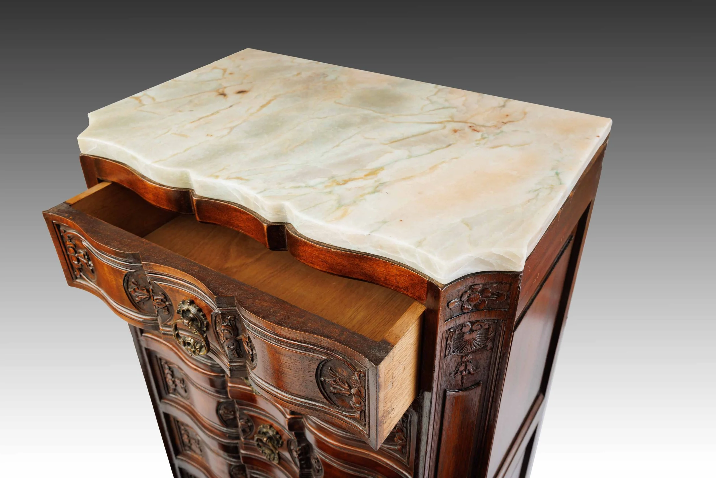 Open drawer view of The Roseroot cabinet showing scalloped quartzite top and curved drawer design with ornate brass hardware.