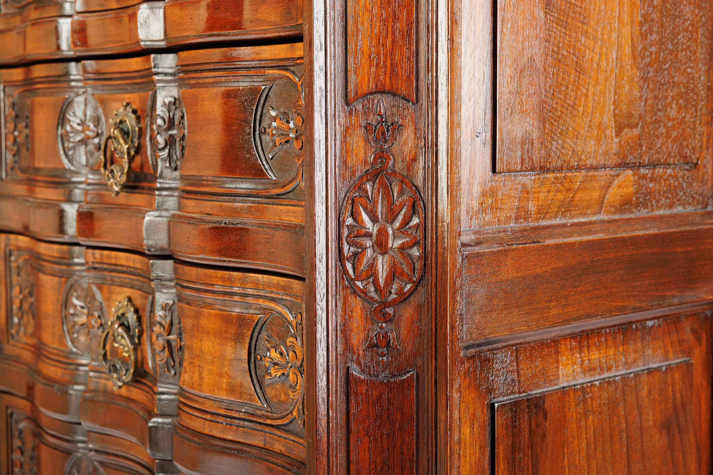 Detailed view of The Roseroot's lower carvings, featuring shell motifs, floral embellishments, and scrolled cabriole legs.