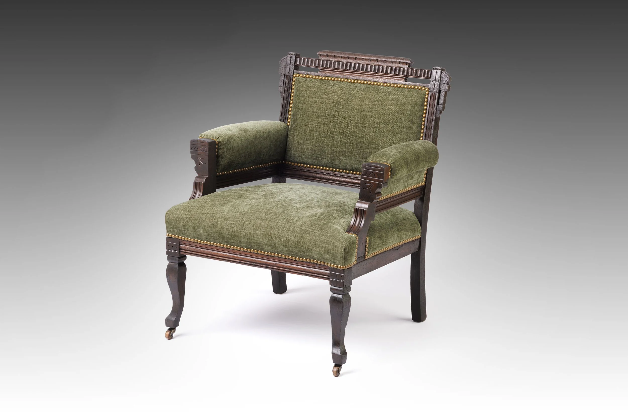 Restored Eastlake armchair upholstered in green linen, rows of brass nailheads following the arms and seat edge, the carved frame refinished