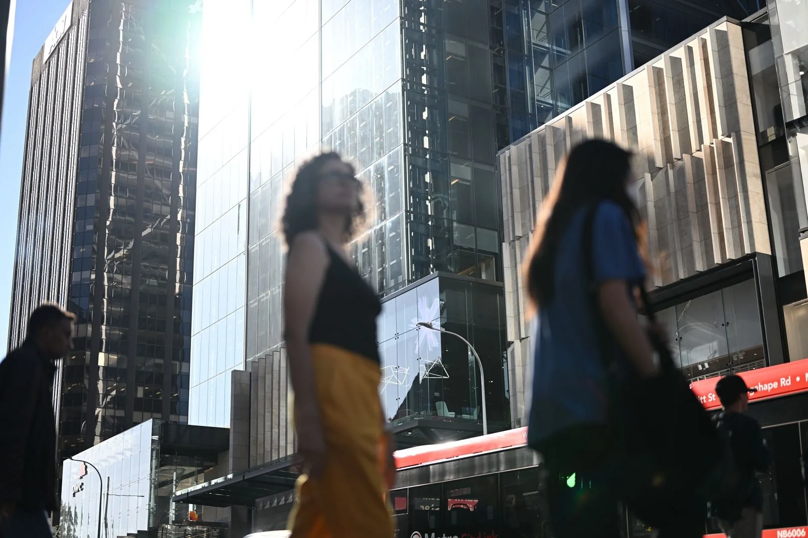 Women crossing the road, high rise glass buildings in the background