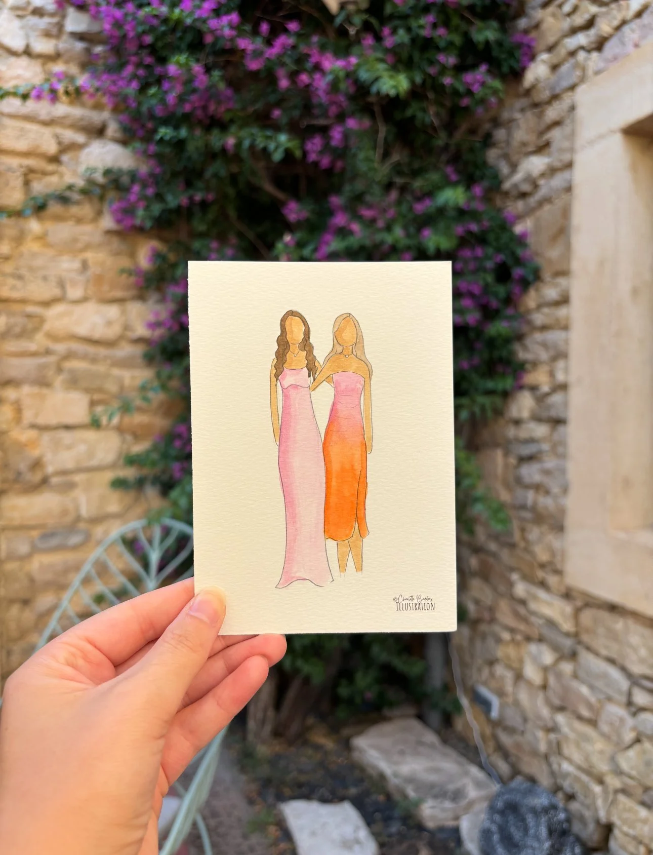 A watercolor illustration of two women in colorful dresses held up against a brick wall with purple flowering plants.
