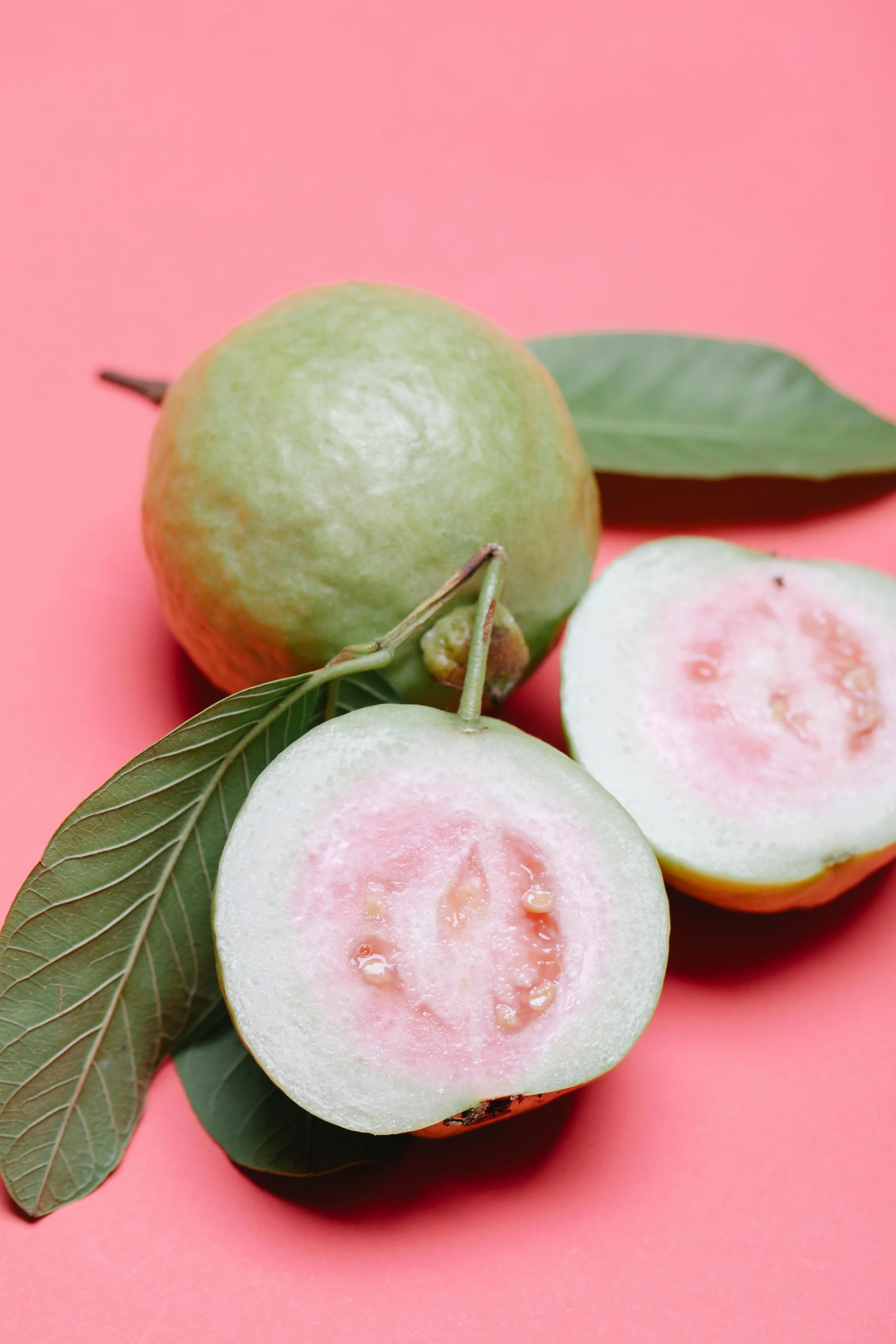 Green and pink fruit with a pink background