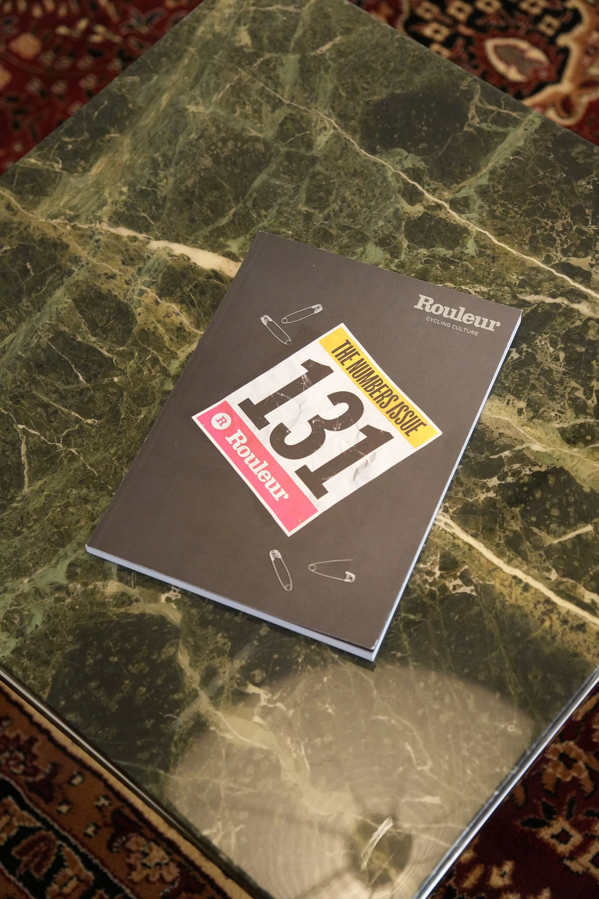 Ein Buch mit dem Titel "The Number Issue 131" auf einem grünen Marmor-Tisch.