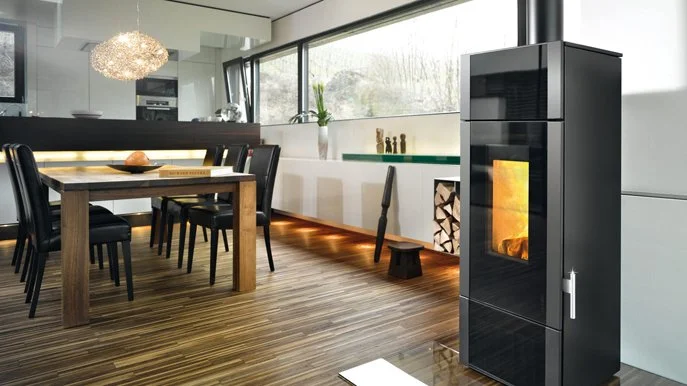 Modernes Wohnzimmer mit Essgruppe und Kaminofen mit Feuer im Vordergrund.