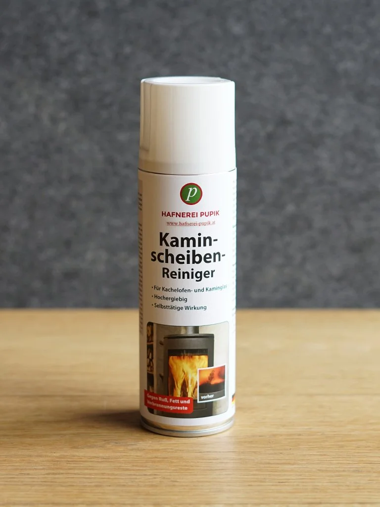 Ein Spraybehälter mit der Bezeichnung "Kaminscheiben-Reiniger" gegen verschmutzte Kamin- und Kachelofen-Glasscheiben.