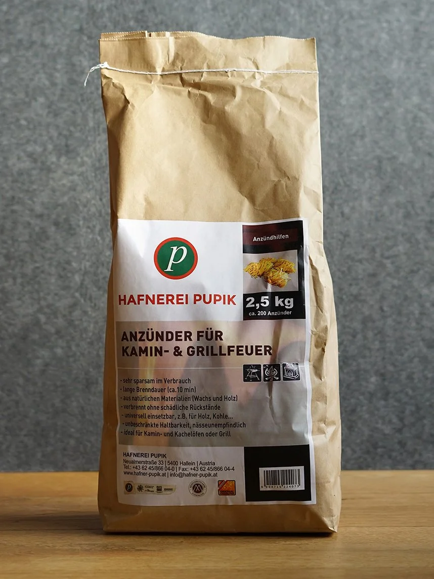 Ein Papiersack mit 2,5 kg Anzündern für Kamin- und Grillfeuer, Marke Hafnerei Pupik.