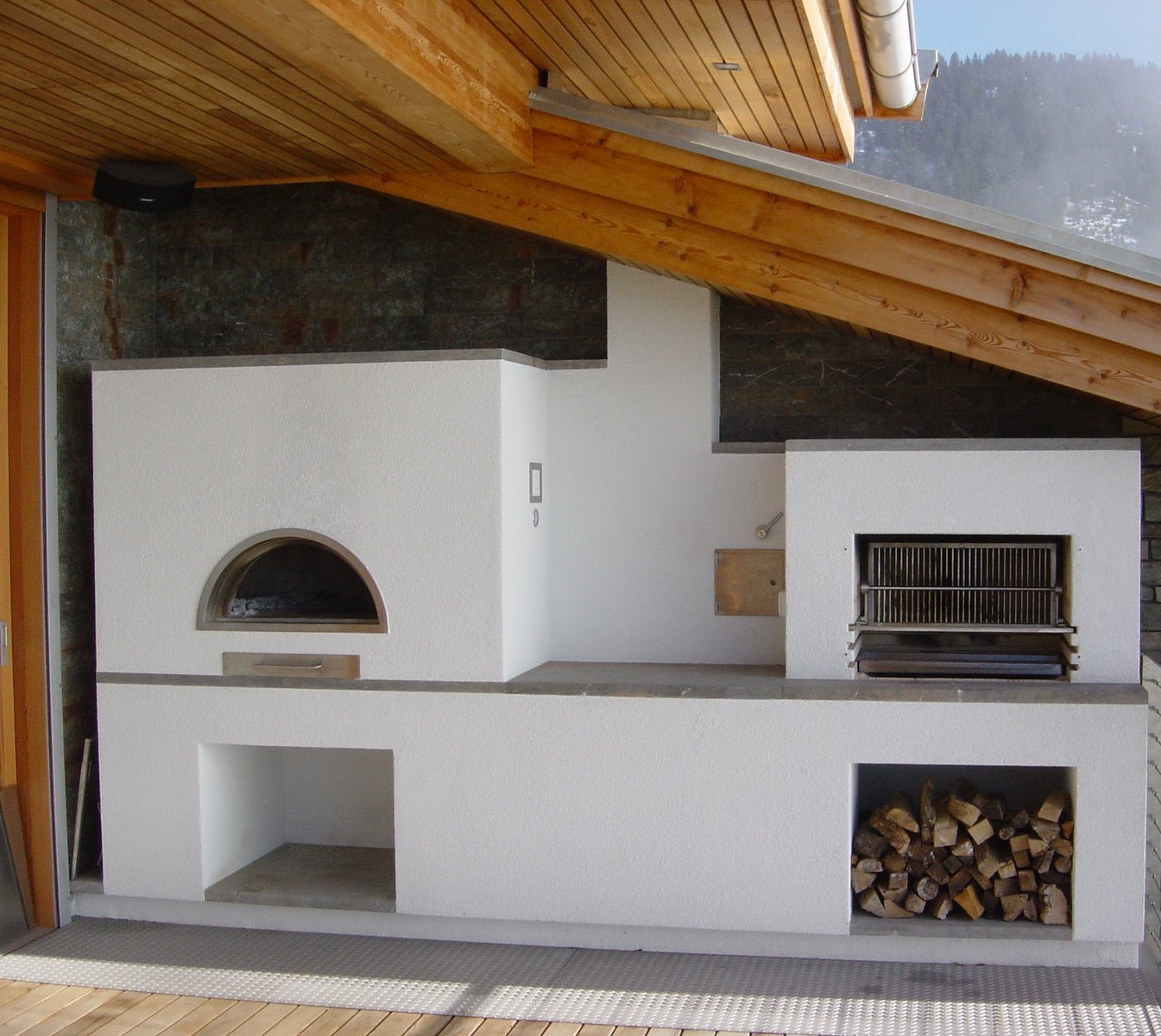 Kamin und Grill im Außenbereich auf einer Terrasse.