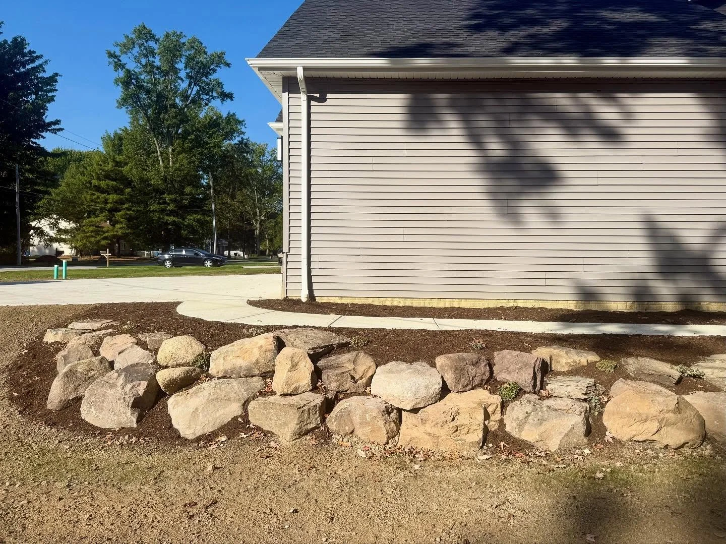 Take a look at this beautiful Pennsylvania Fieldstone boulder wall we built. These natural boulders create a stunning landscape feature at a more affordable cost compared to a traditional retaining wall&mdash;plus they blend seamlessly with the surro