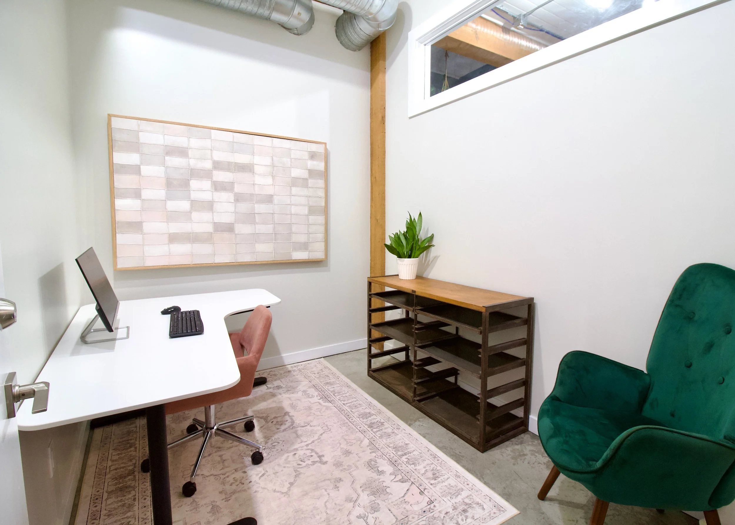 A warm and inviting studio office for rent with monitor, for photo shoots or editing.