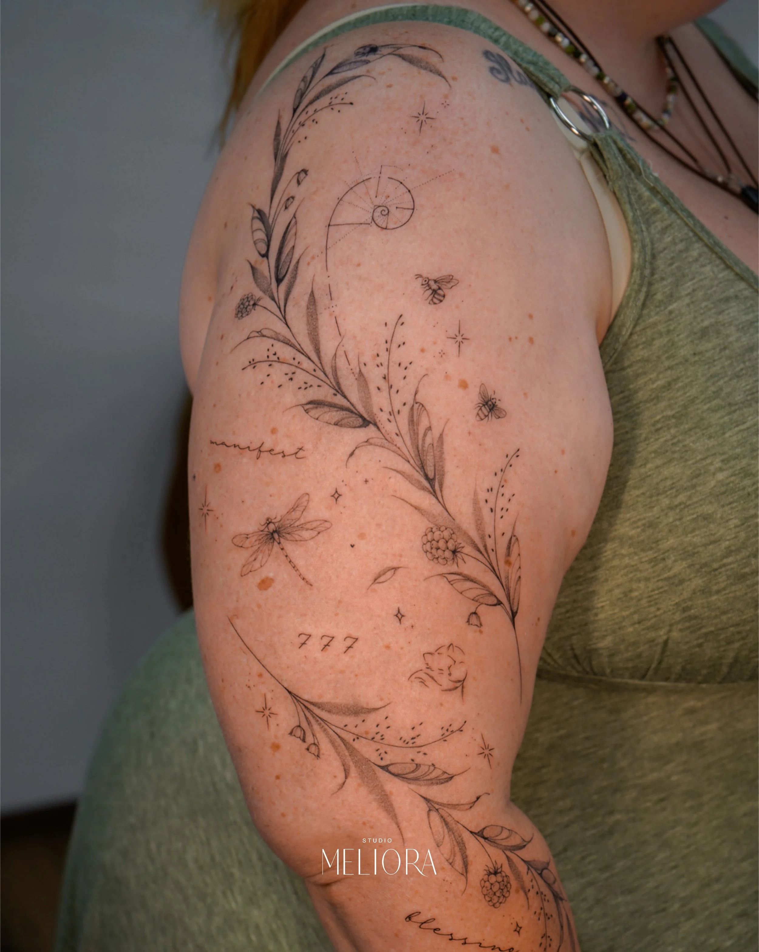 Dieses wundervolle, verspielte Oberarm-Tattoo ist einfach zauberhaft. Mit seinen liebevollen Details erz&auml;hlt es eine ganz besondere Geschichte und zieht alle Blicke auf sich.🌿

Artist: @szilvi.tattoo 

Termine im Juli und August noch verf&uuml;