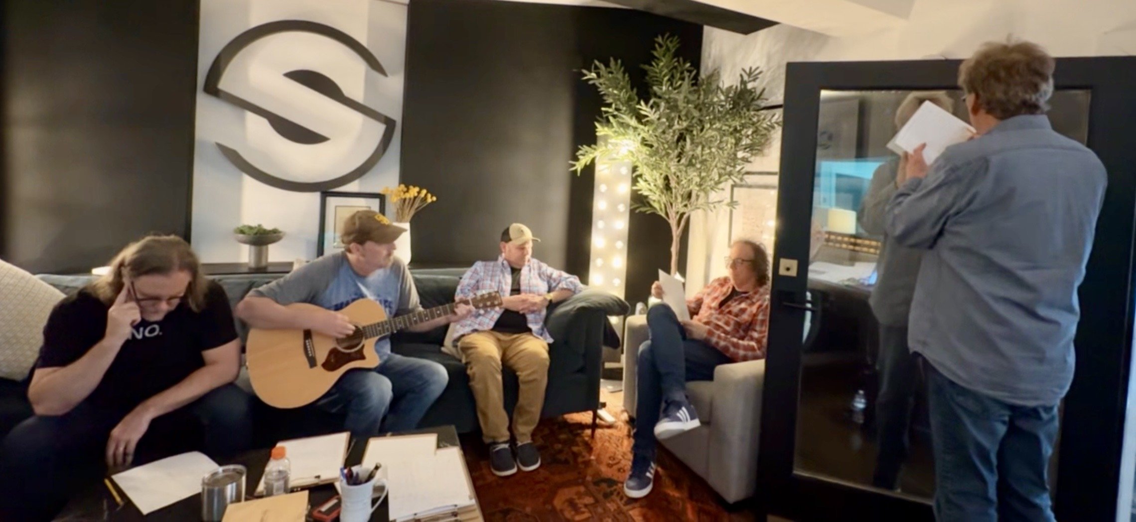 Artists, producers, and Nashville session musicians reviewing a song together before recording at a Century Music Group session in Nashville.