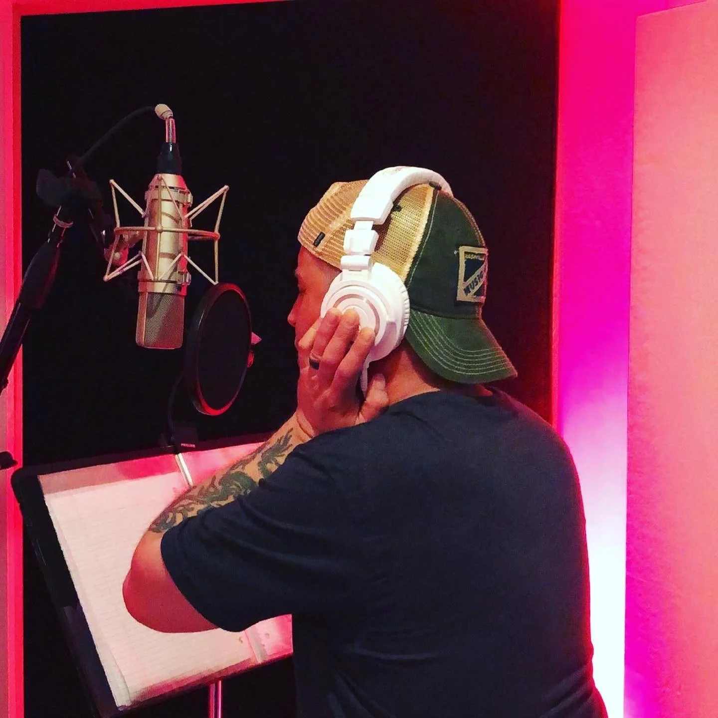 Singer-songwriter recording vocals in a Nashville recording studio during a professional music production session.