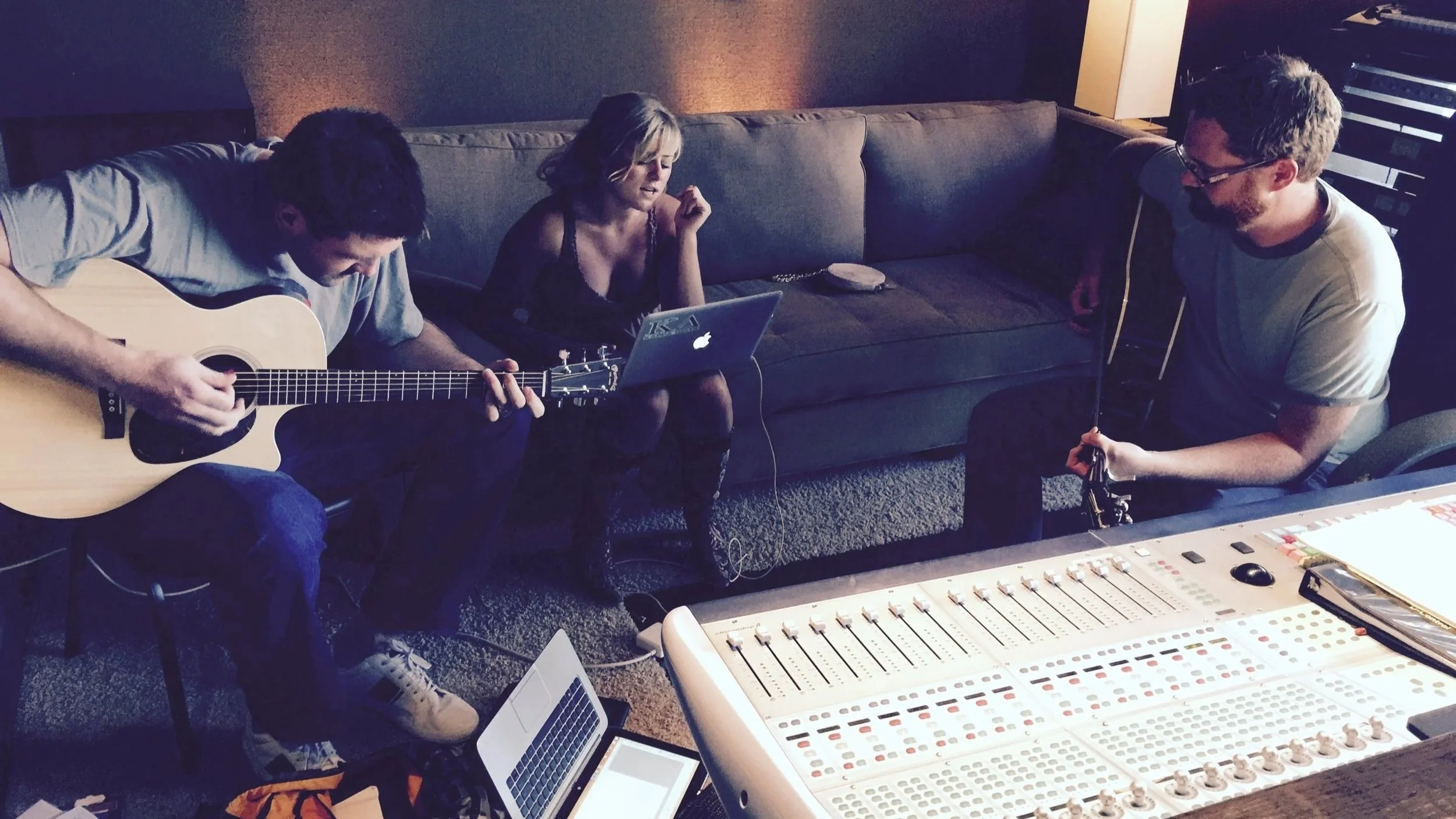 Singer-songwriters collaborating in a Nashville recording studio during a songwriting session.