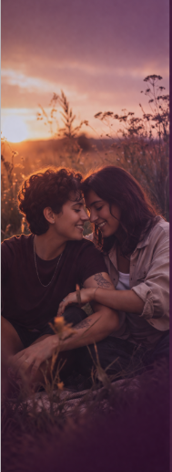 Queer couple sitting together in warm light, representing feeling safe in relationships and being yourself in queer therapy
