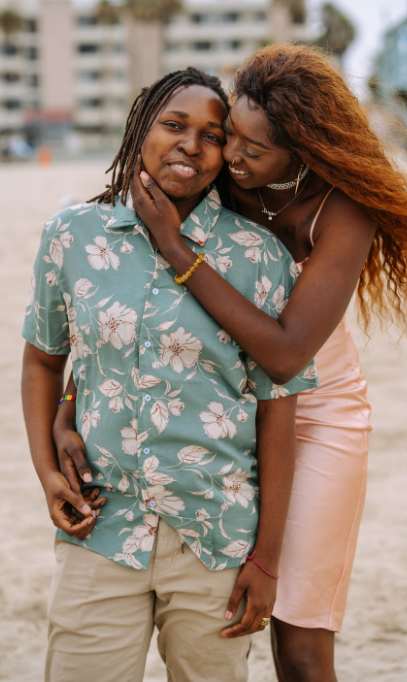 Two people embracing and smiling together outdoors.