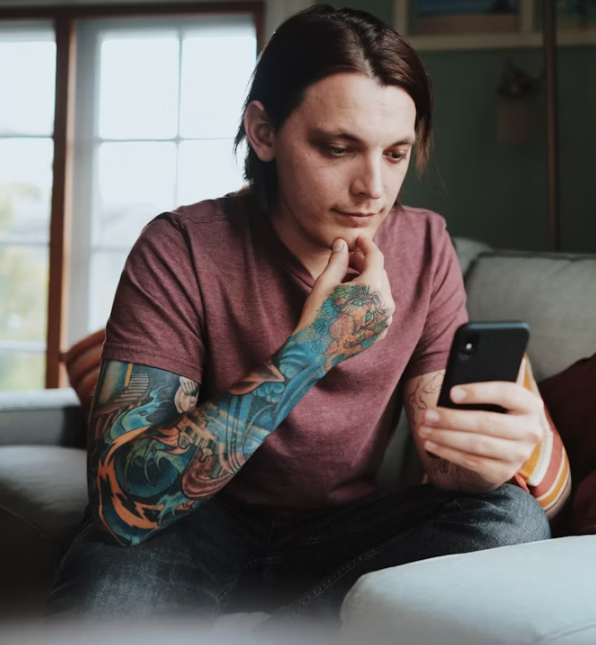 LGBTQIA+ adult putting their phone down while practicing how to stop over-explaining and trust their communication.