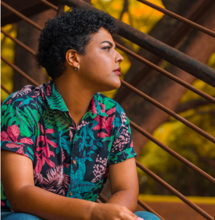 Person in a colorful floral shirt sitting outdoors, representing authenticity and LGBTQIA+ affirming therapy