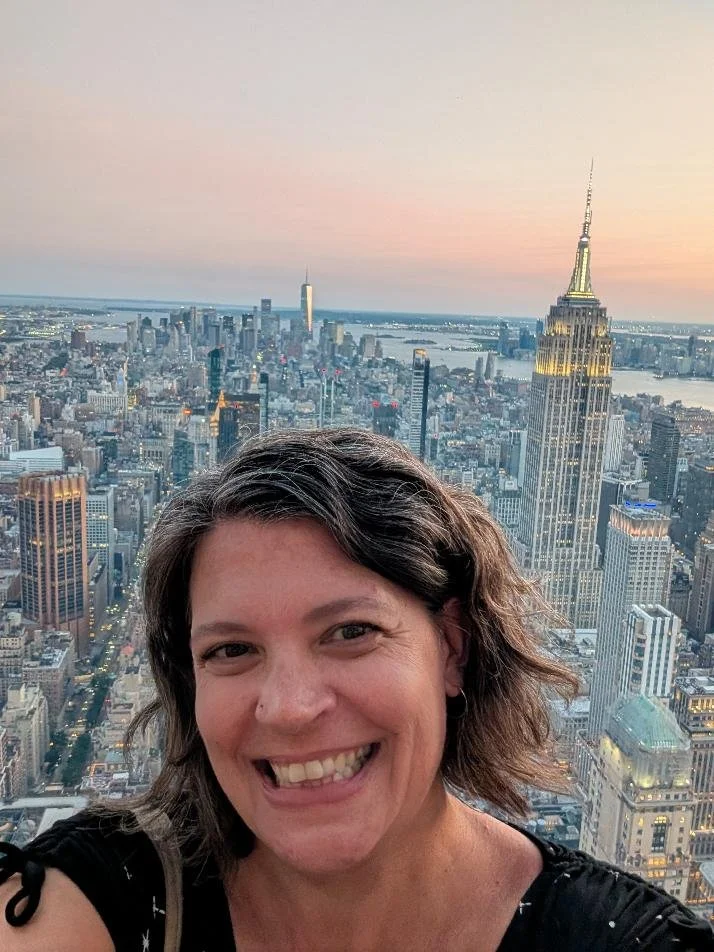a smiling woman who is a teacher, and a reading and math tutor in woodstock. she is on vacation in the photo