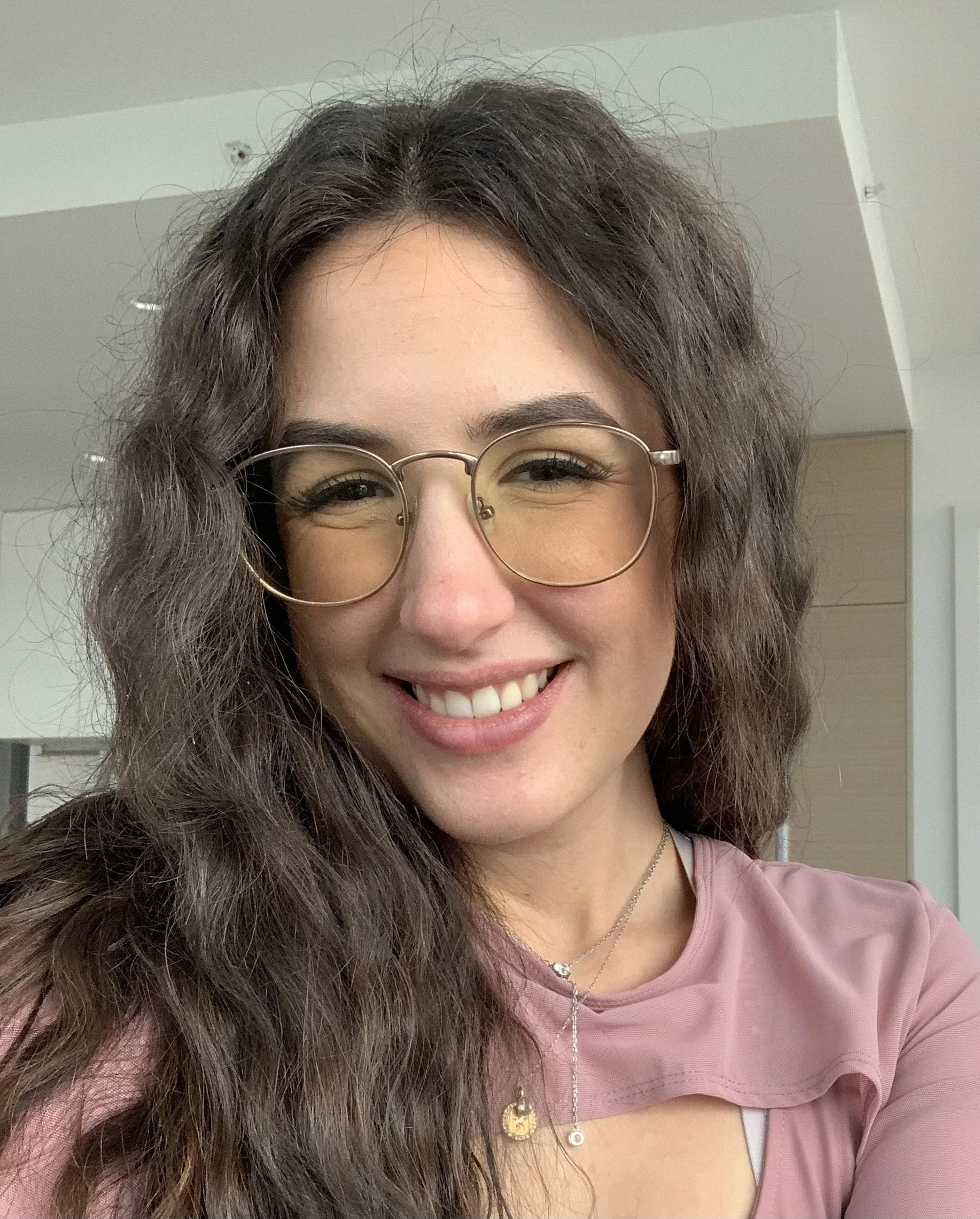 A smiling woman who works at the learning hive in woodstock as a french tutor