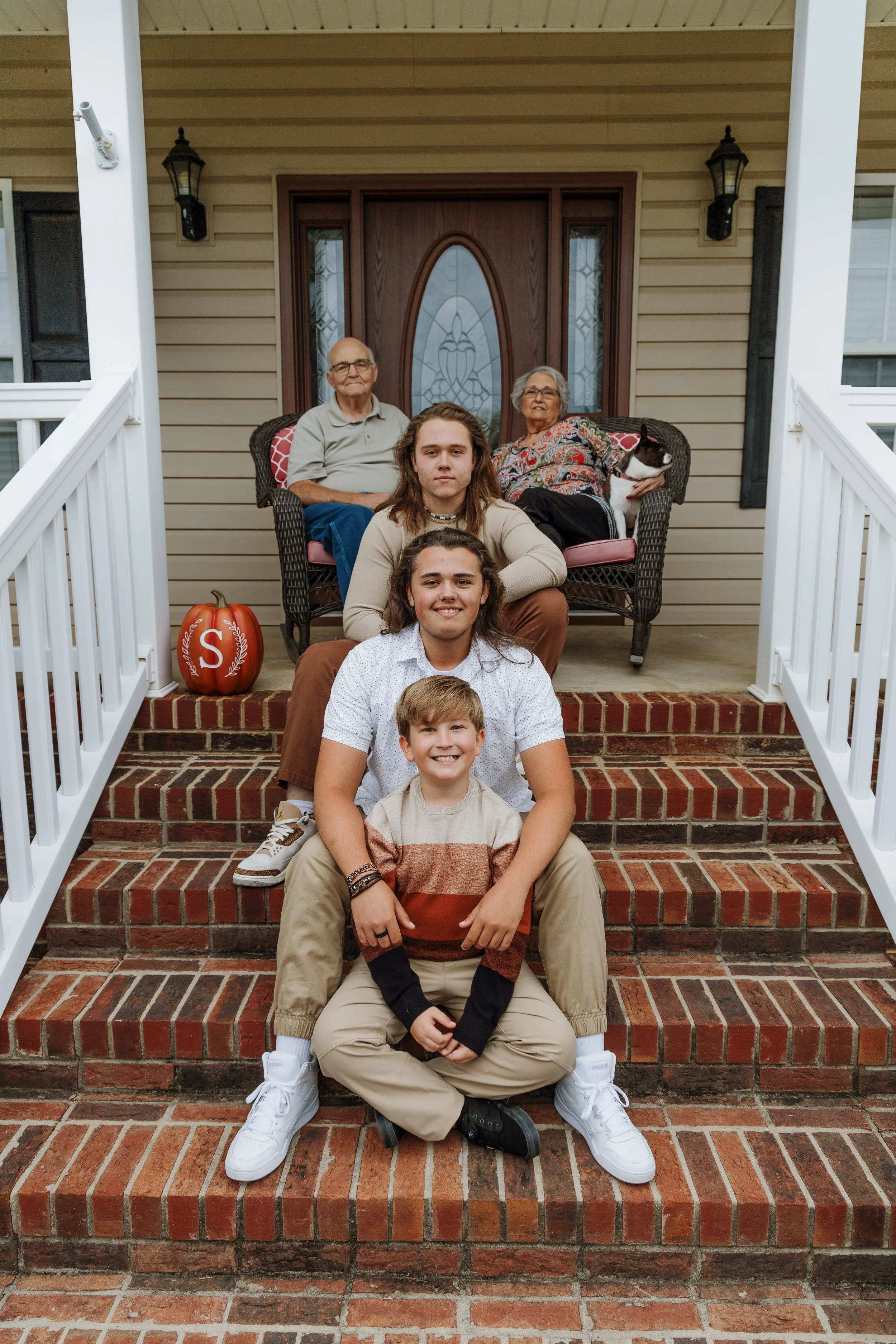 Family lying on the floor together, smiling and looking at each other, including a woman, a baby, and a man.