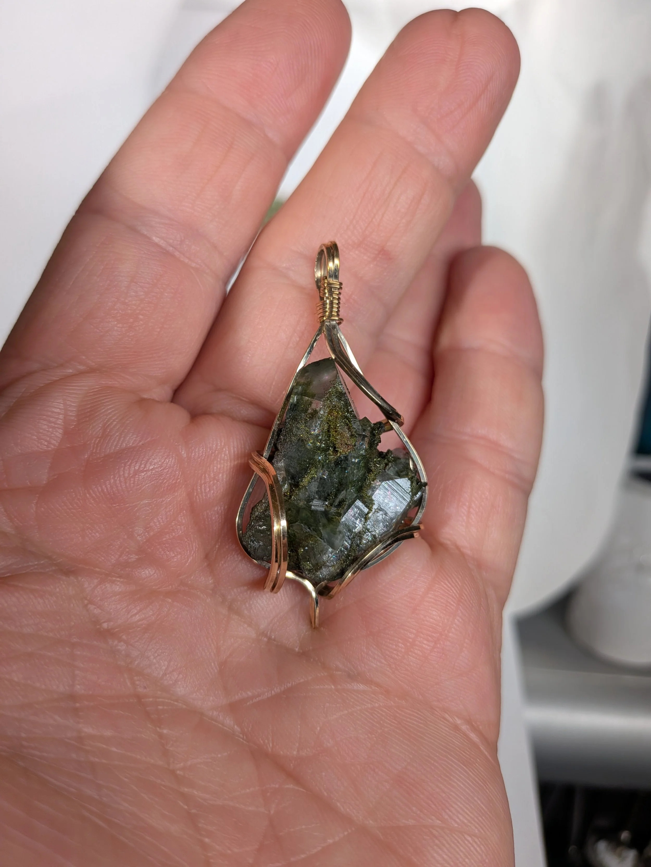 Gorgeous raw epidote, intricately wire-wrapped, beautifully highlighting the stone as the centrepiece.