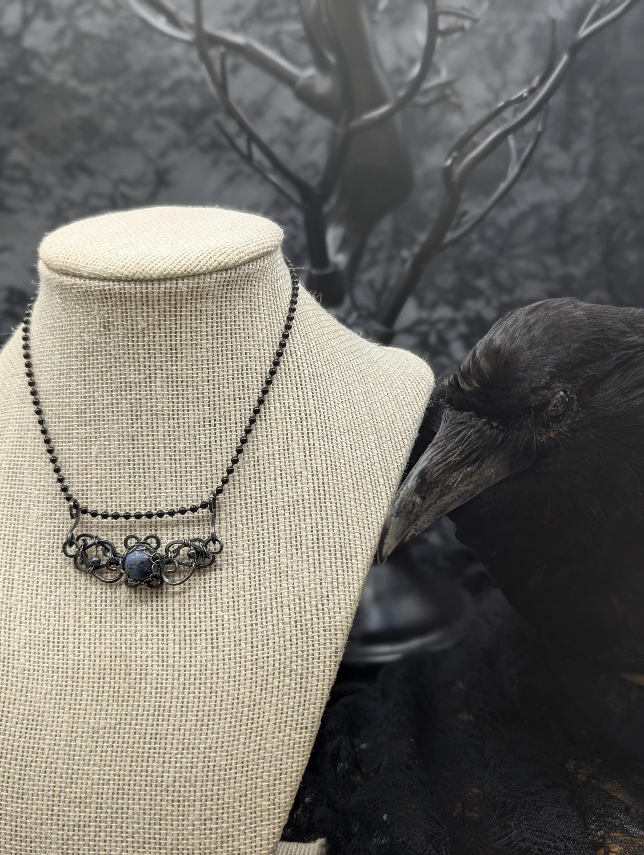A petite pietersite gemstone elegantly wrapped in antiqued sterling swirling square wire.