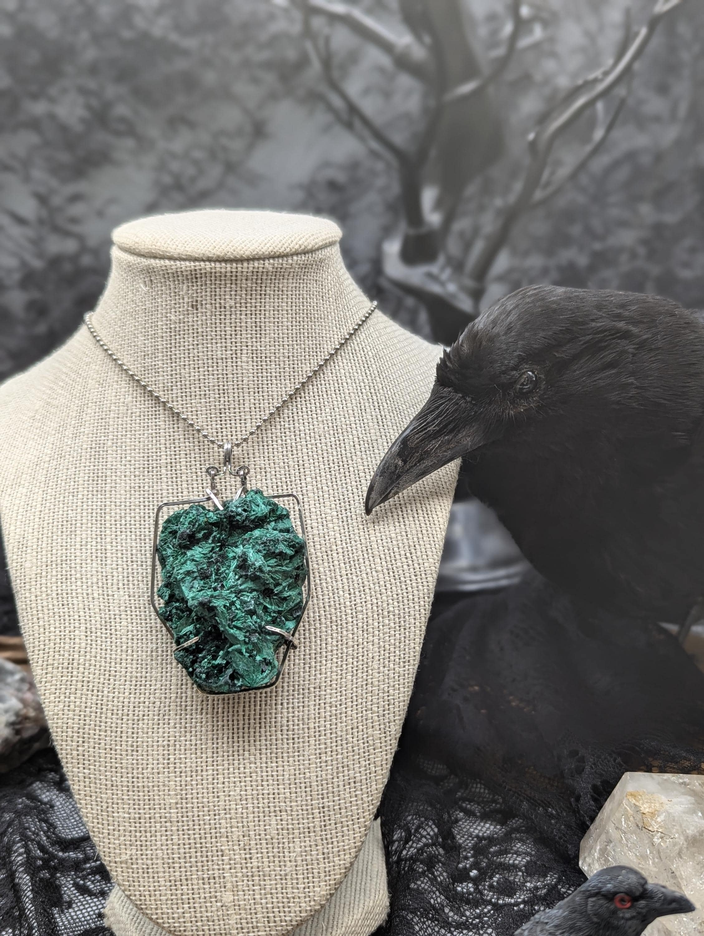 A sterling silver free-swinging, wire-wrapped claw pendant holds an extra-large velvet malachite gemstone, making it the focal point of this statement piece.