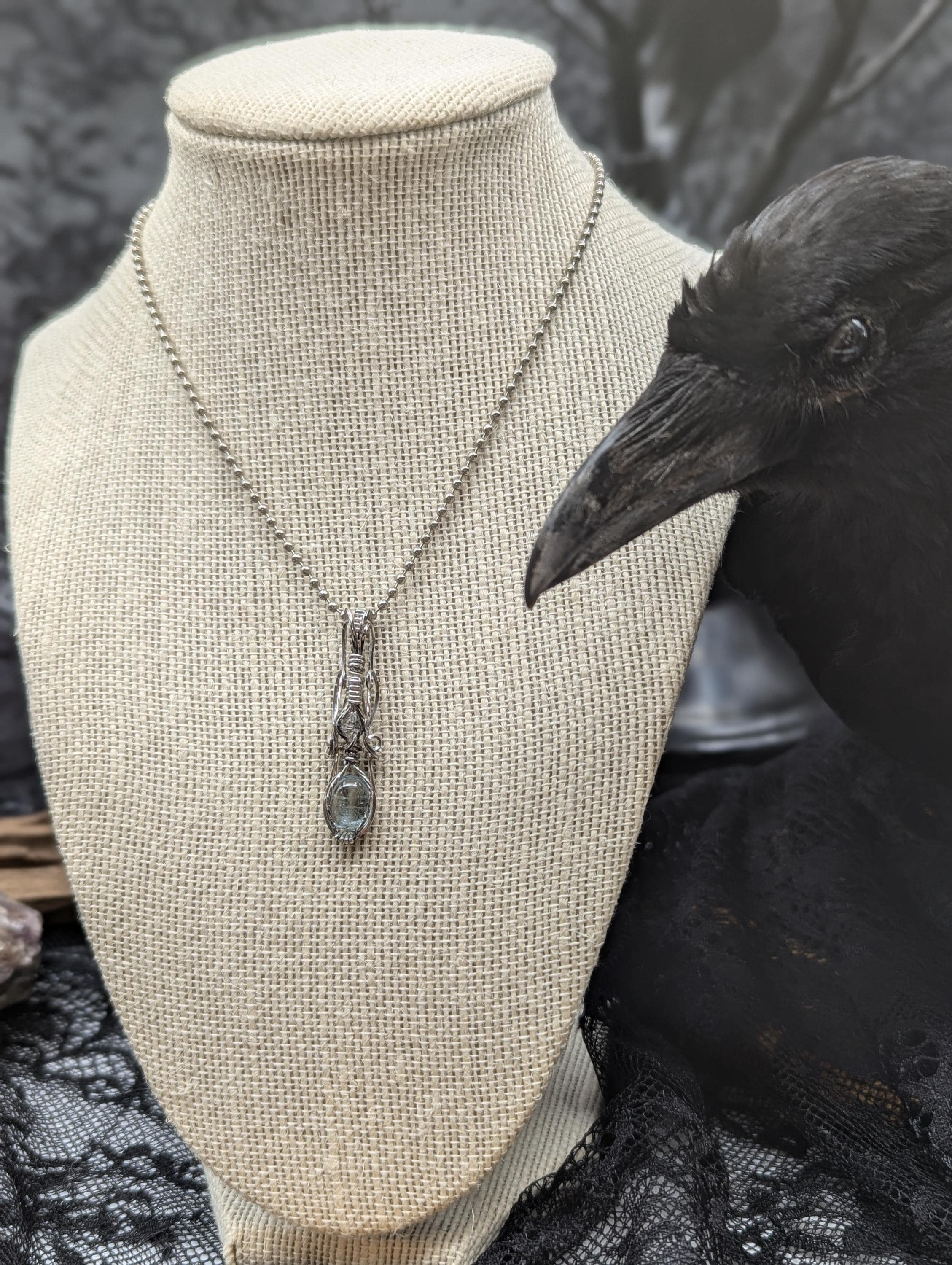 Elegant petite aquamarine and Herkimer diamond beautifully wire-wrapped in sterling, featuring a cascading bail that draws attention to the stunning gemstones.