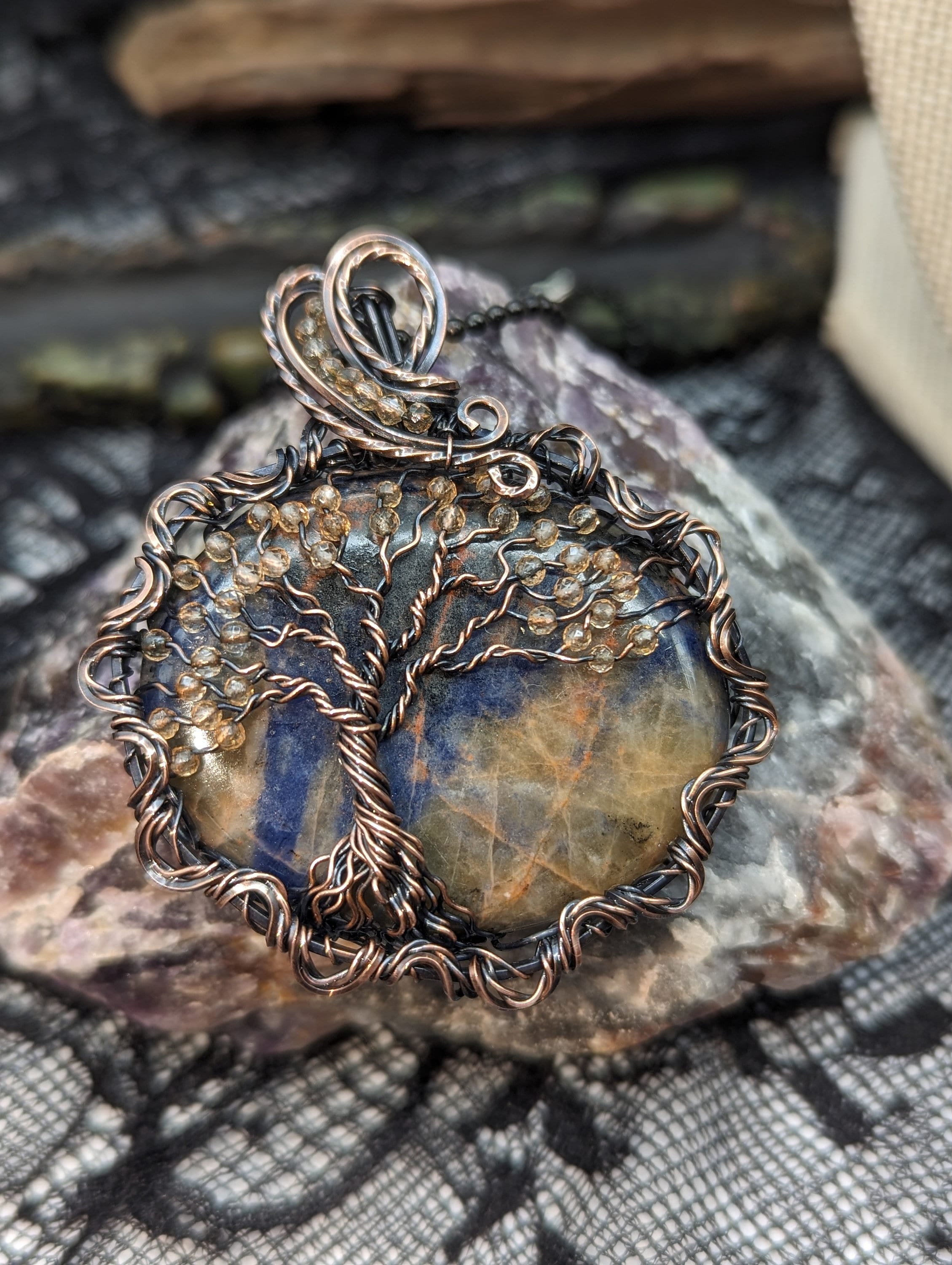 Orange Sodalite thumb stone pendant for meditation, wire wrapped with a Tree of Life and citrine bead accents, featuring an elegant twisted copper wire border.