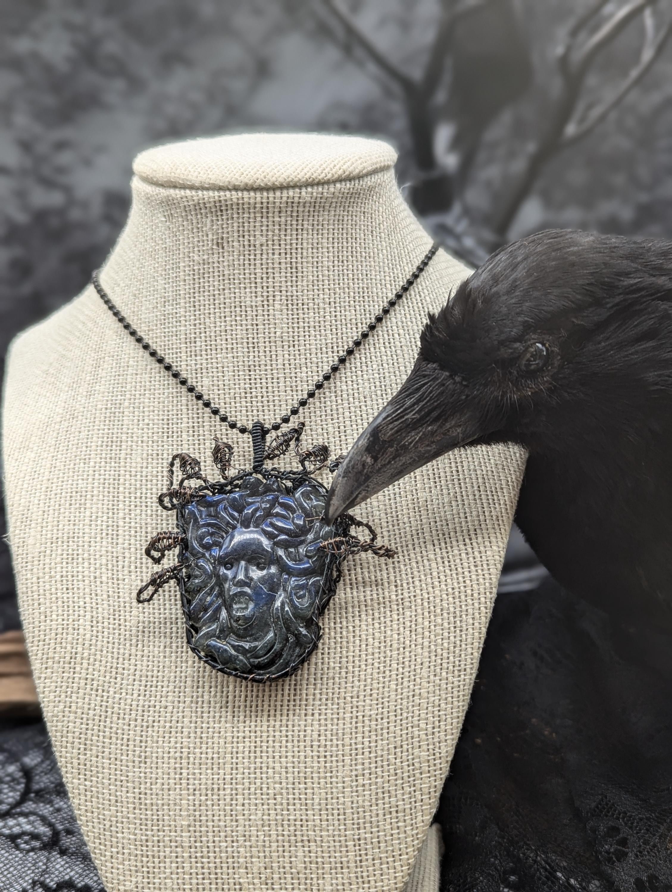 A beautifully carved blue medusa head pendant, wire-wrapped in copper, features 10 intricate 3D snake heads elegantly positioned around and above it.