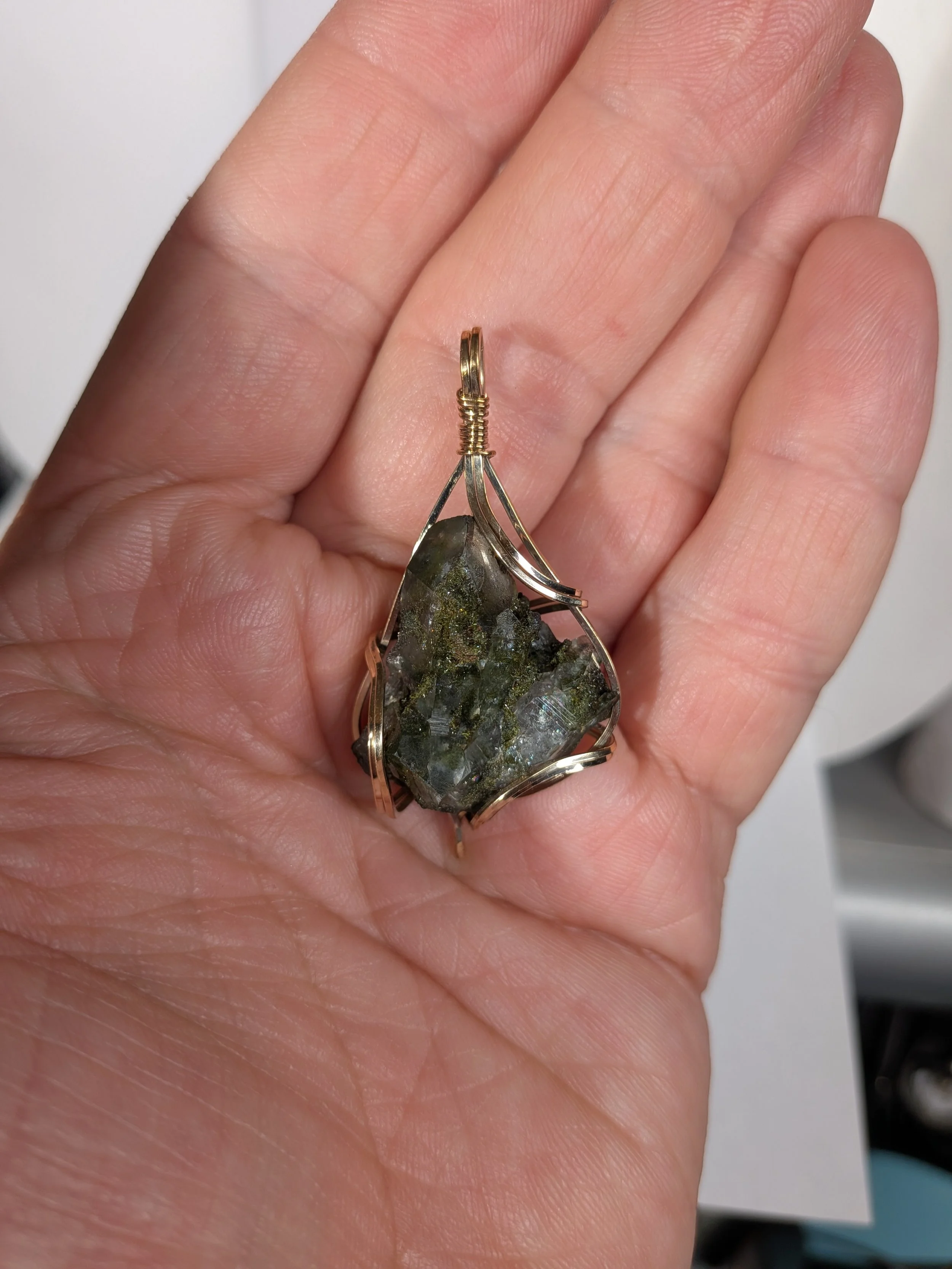 Gorgeous raw epidote, intricately wire-wrapped, beautifully highlighting the stone as the centrepiece.